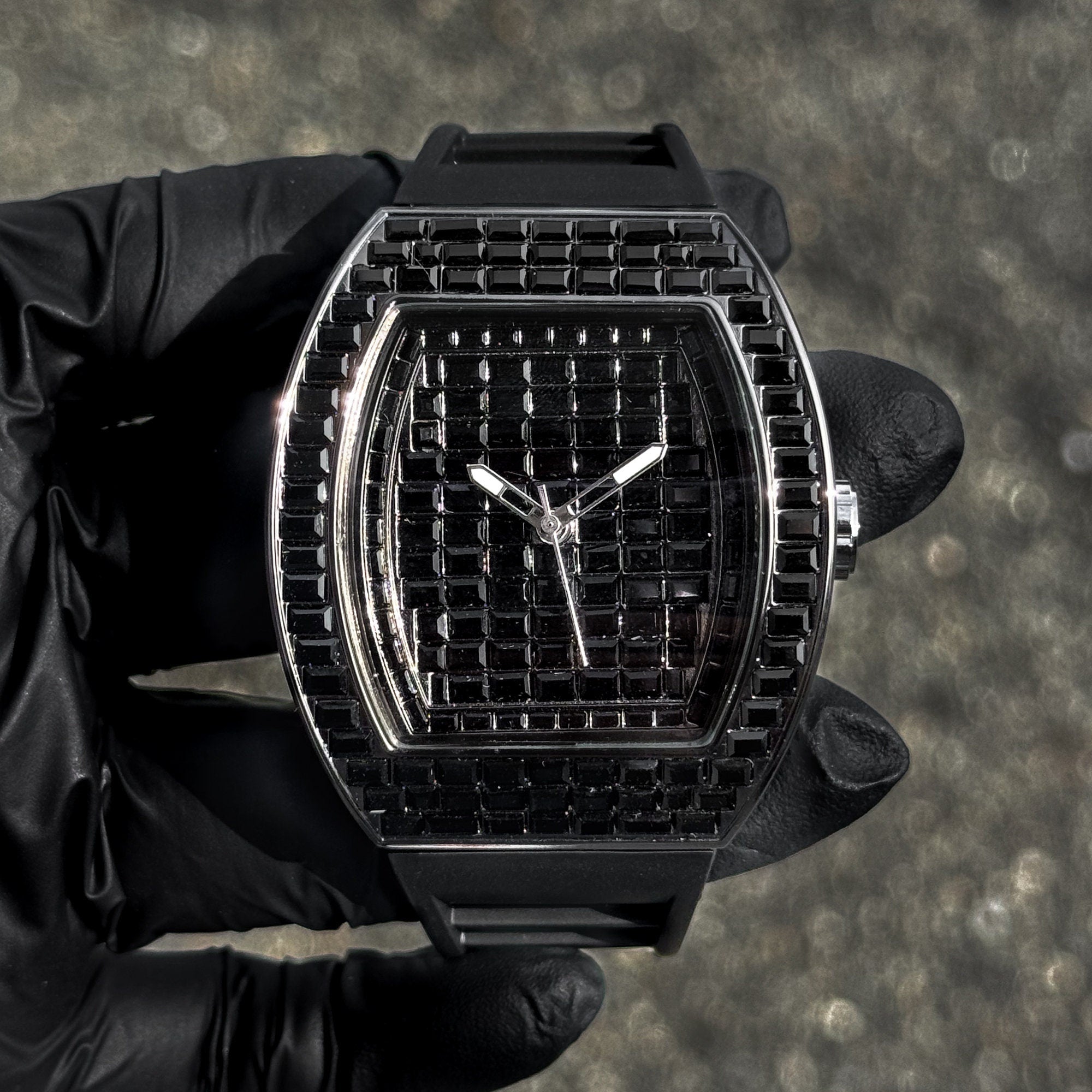 Men’s 43mm black iced out tonneau watch with black baguette crystals and matching silicone band.