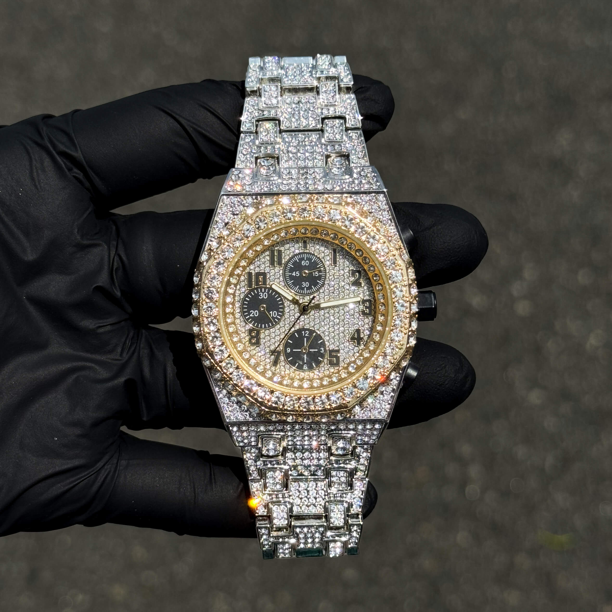 Men's 42mm two-tone iced out diamond watch with gold bezel and octagon case on link band.