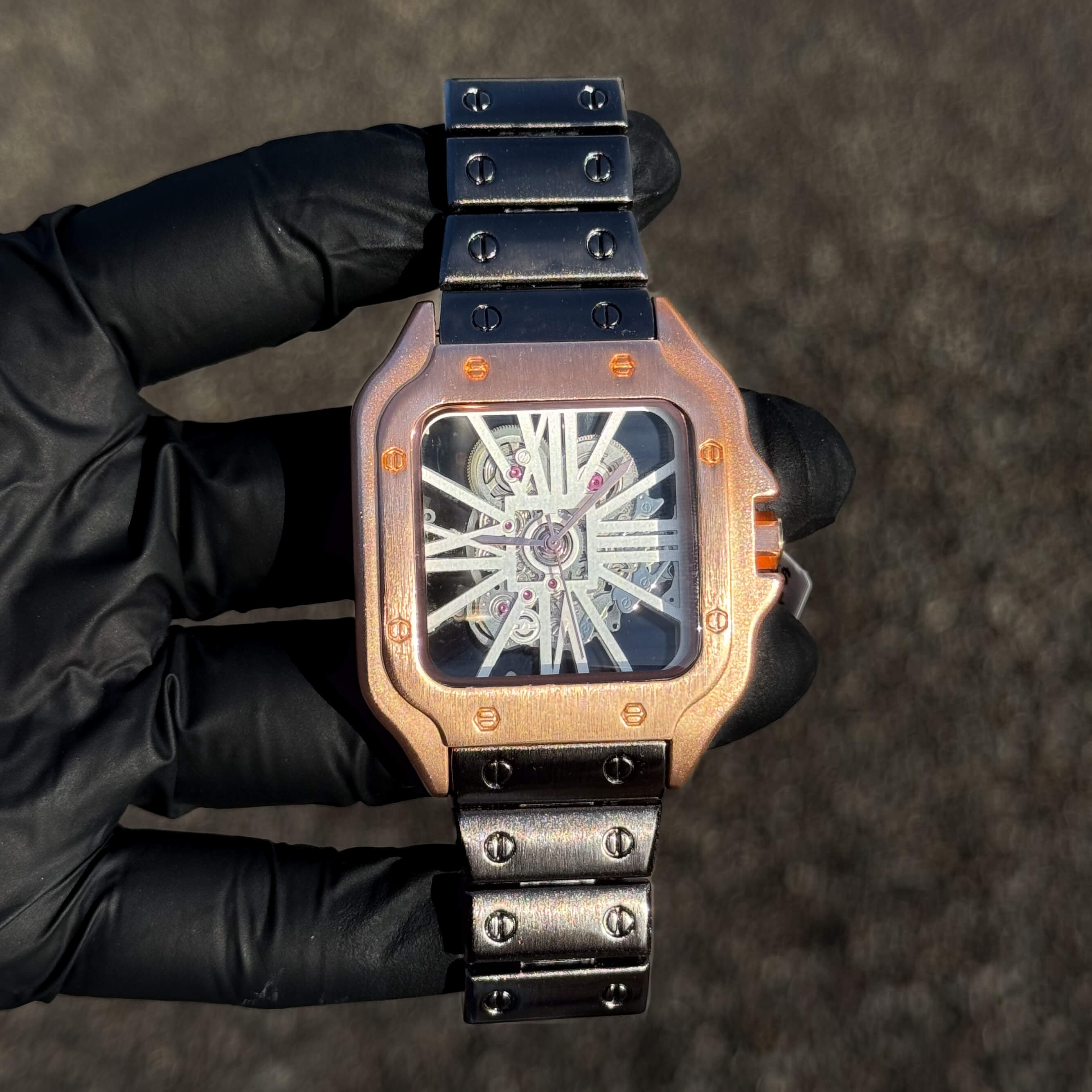 Men's 40mm rose gold square watch featuring skeleton dial and gun-finish metal bracelet.