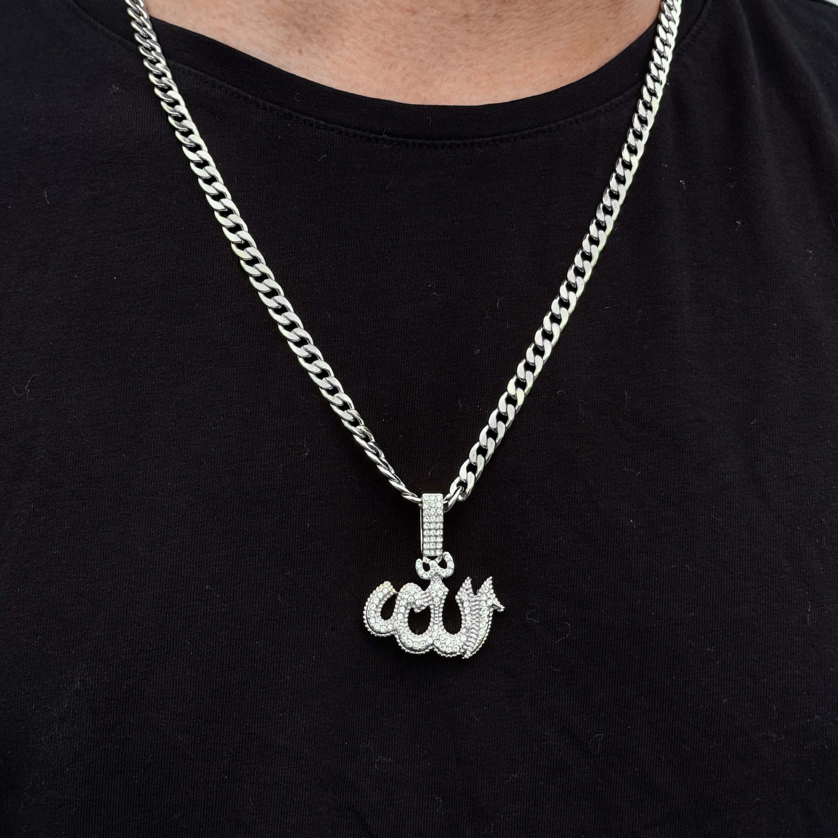 Silver 35mm iced-out Allah pendant on model paired with 6mm Cuban chain against black shirt.