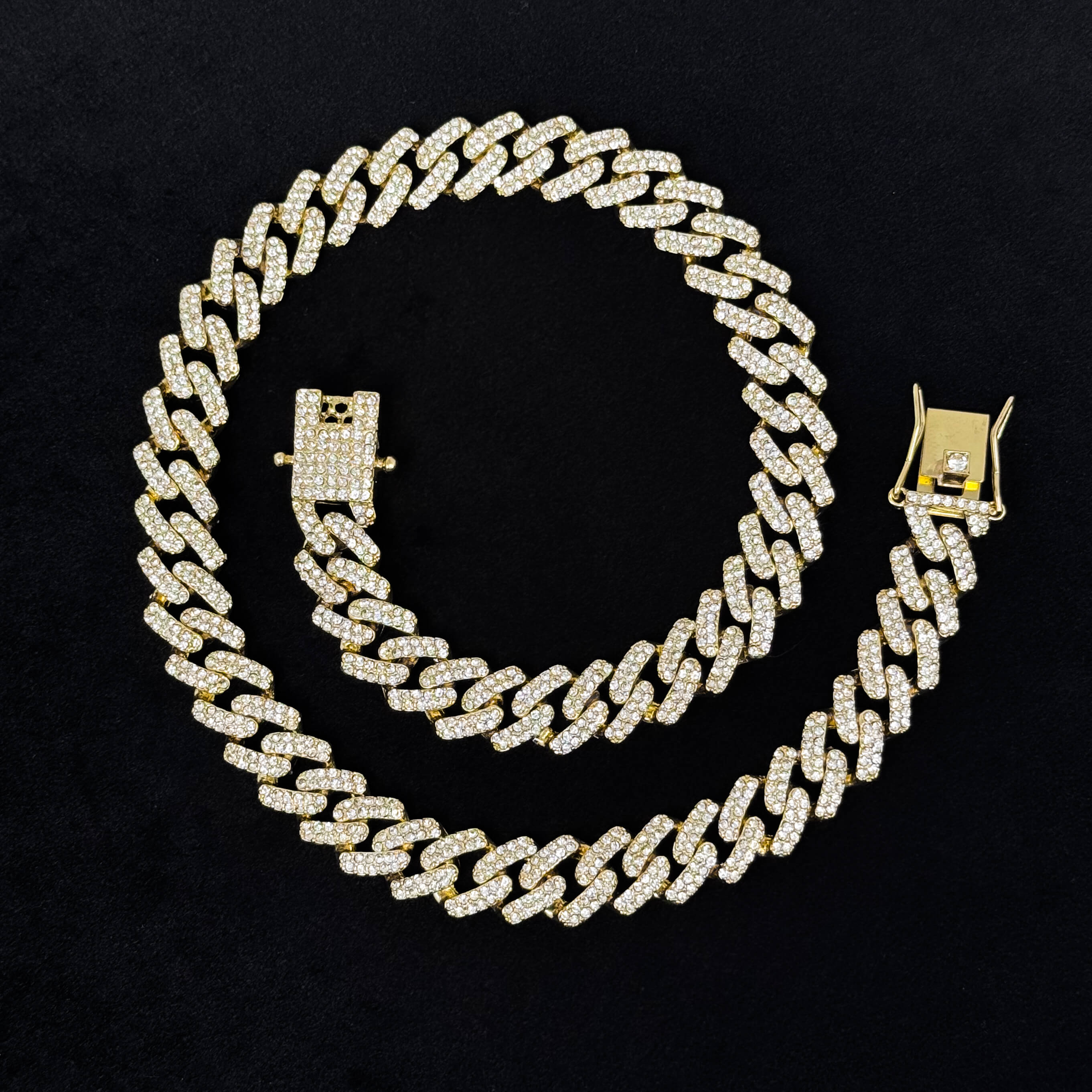 12mm Iced Out Cuban Chain gold necklace laid flat on black background, full pavé links and secure clasp.