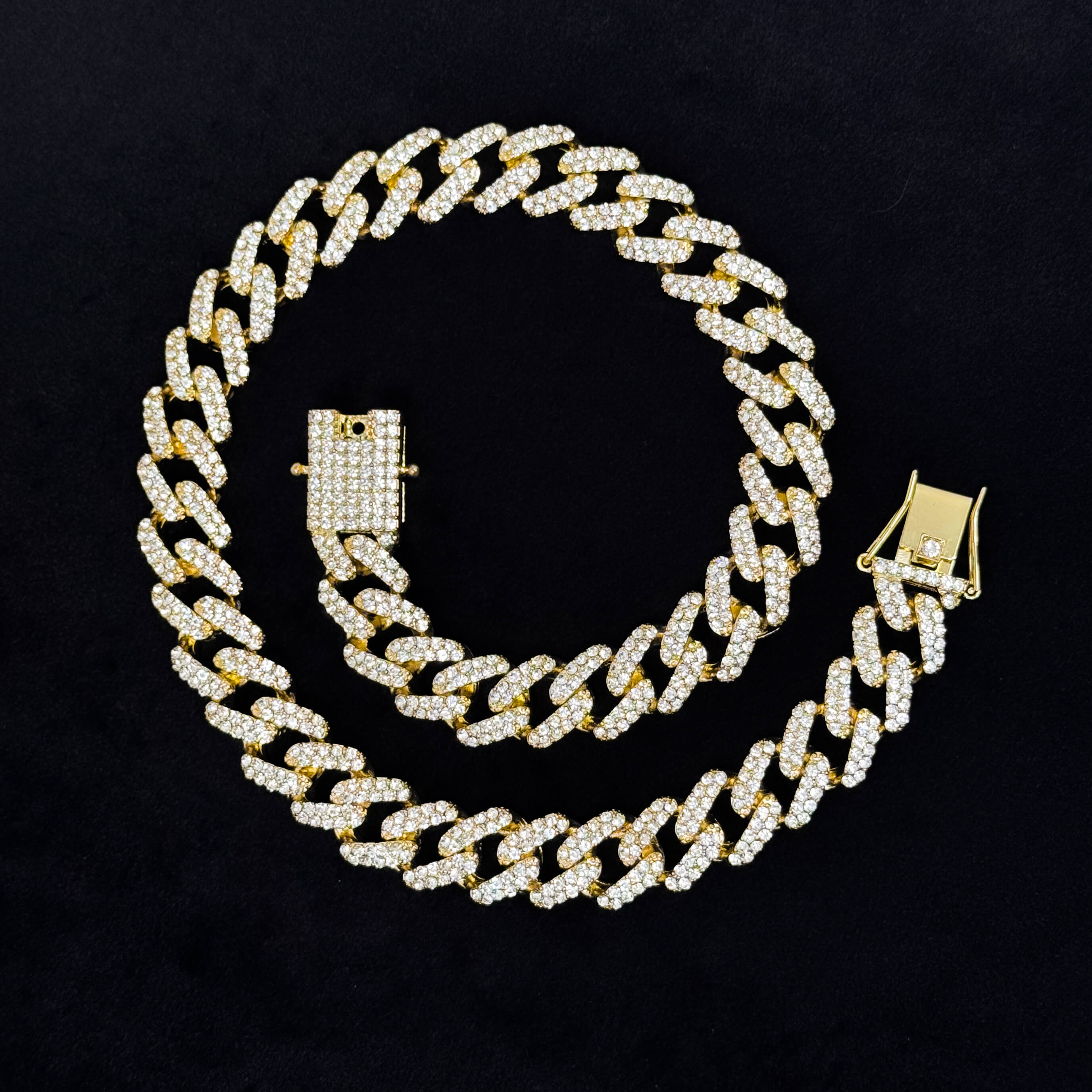 15mm Iced Out Cuban Chain gold necklace laid flat on black surface, full pavé links and box clasp detail.