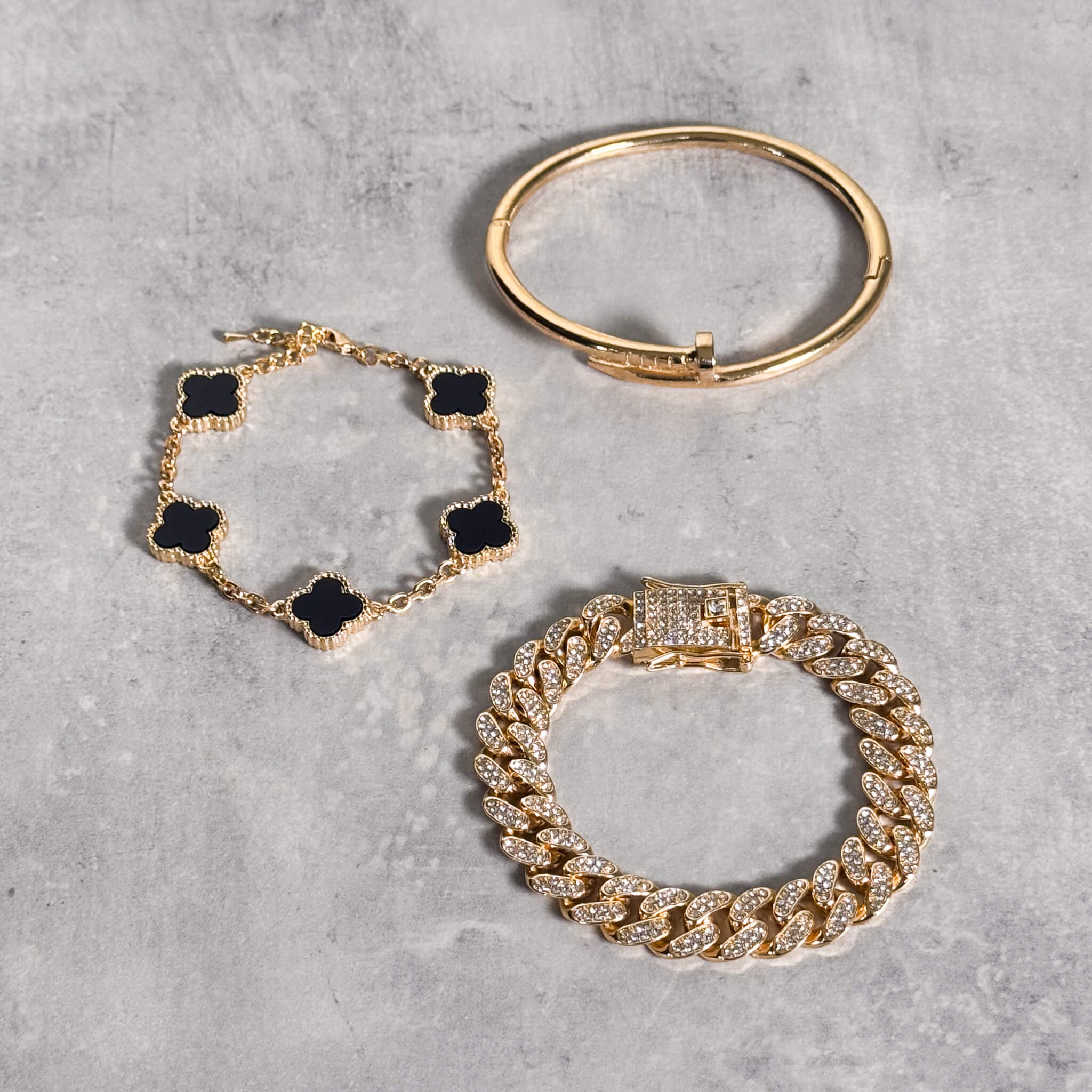 Gold clover chain bracelets in red, white, black, and green enamel for elegant styling.