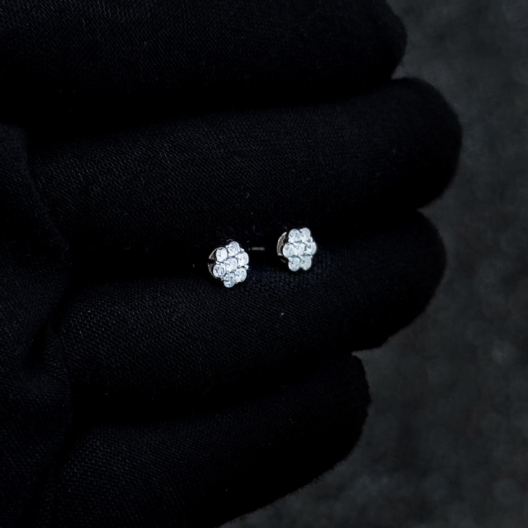 Side angle of 6mm Moissanite cluster earrings featuring 0.53ct diamond studs on black glove.