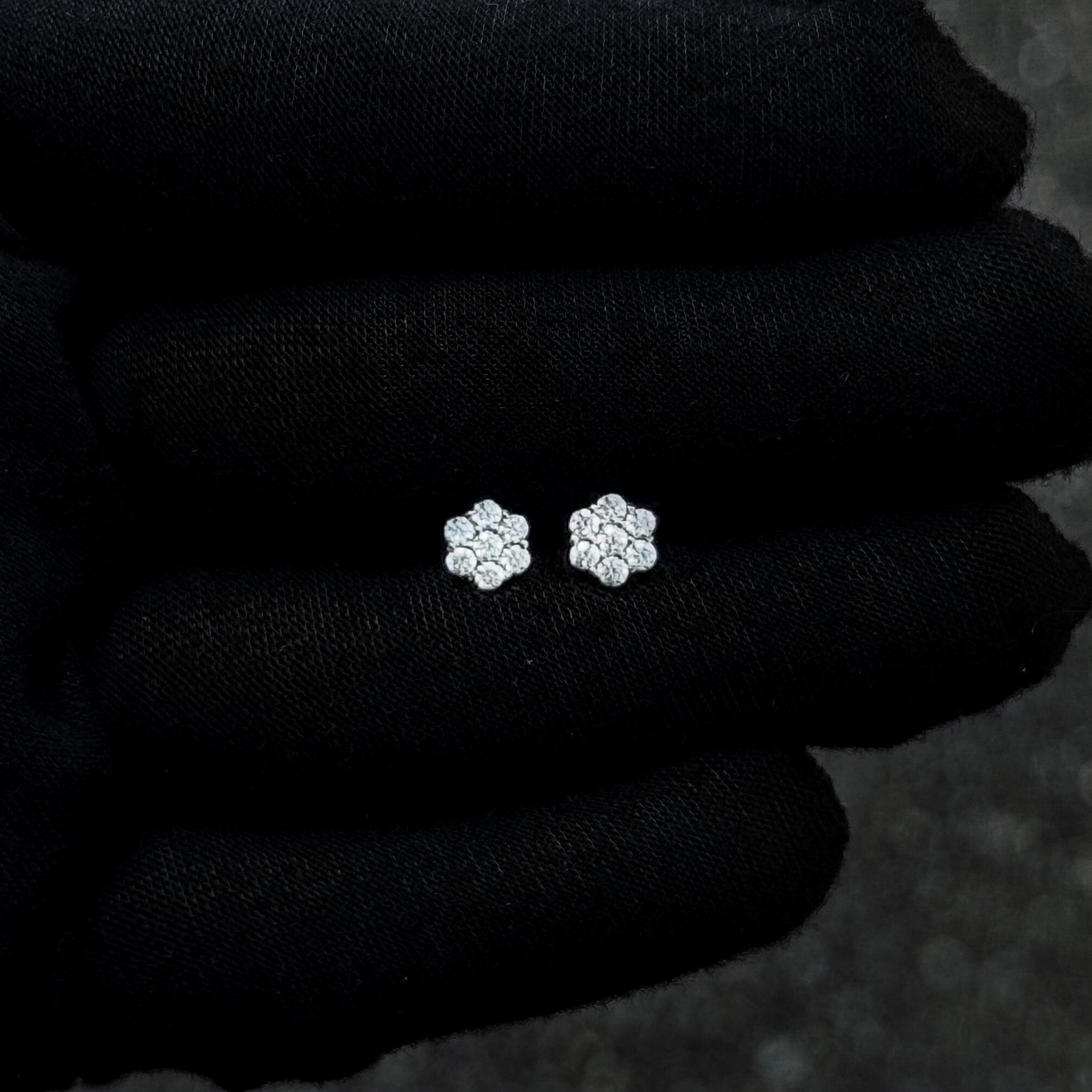 Tiny 6mm sterling silver Moissanite cluster stud earrings shown on black glove for size detail.