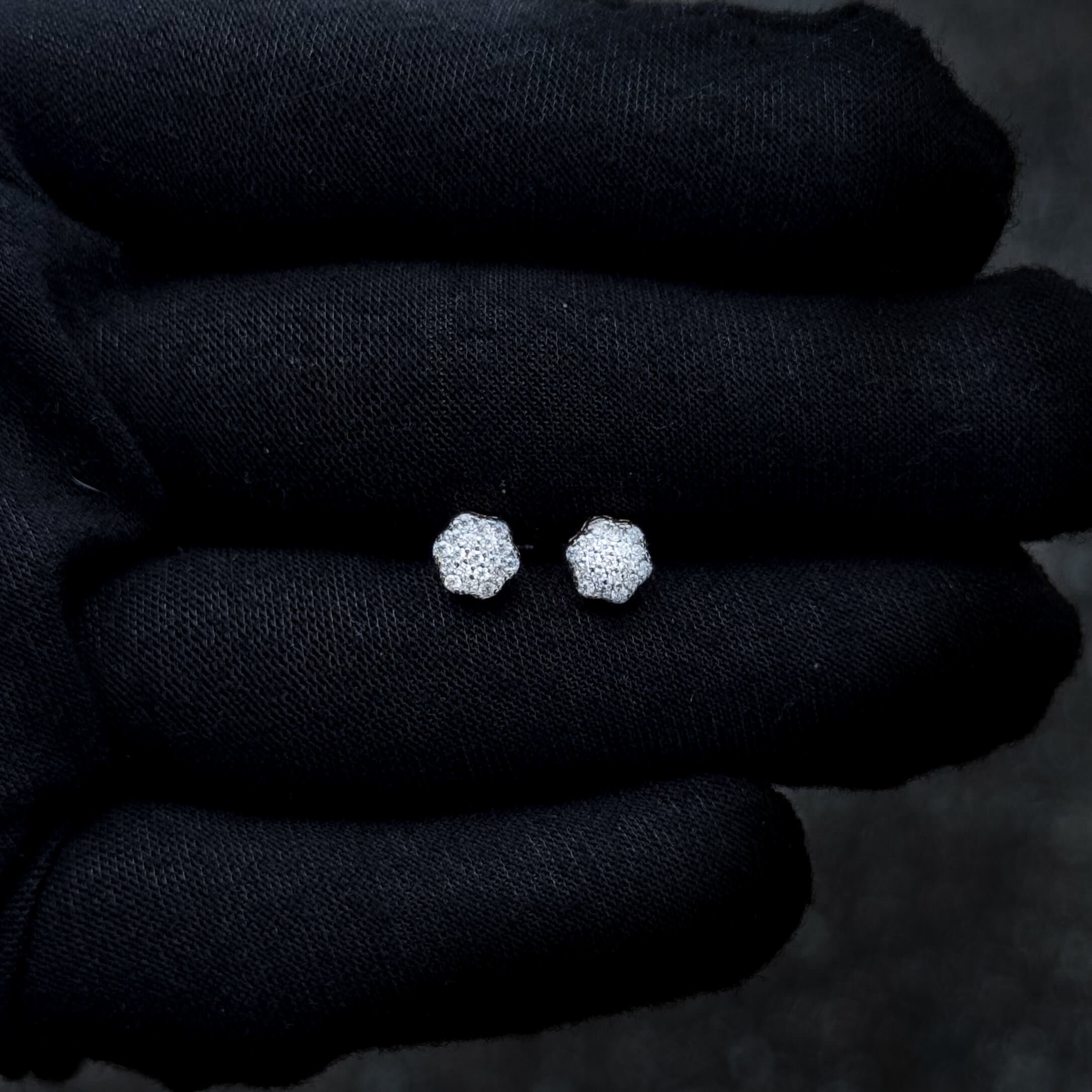 Floral 6mm moissanite cluster earrings in sterling silver shown against a dark background.