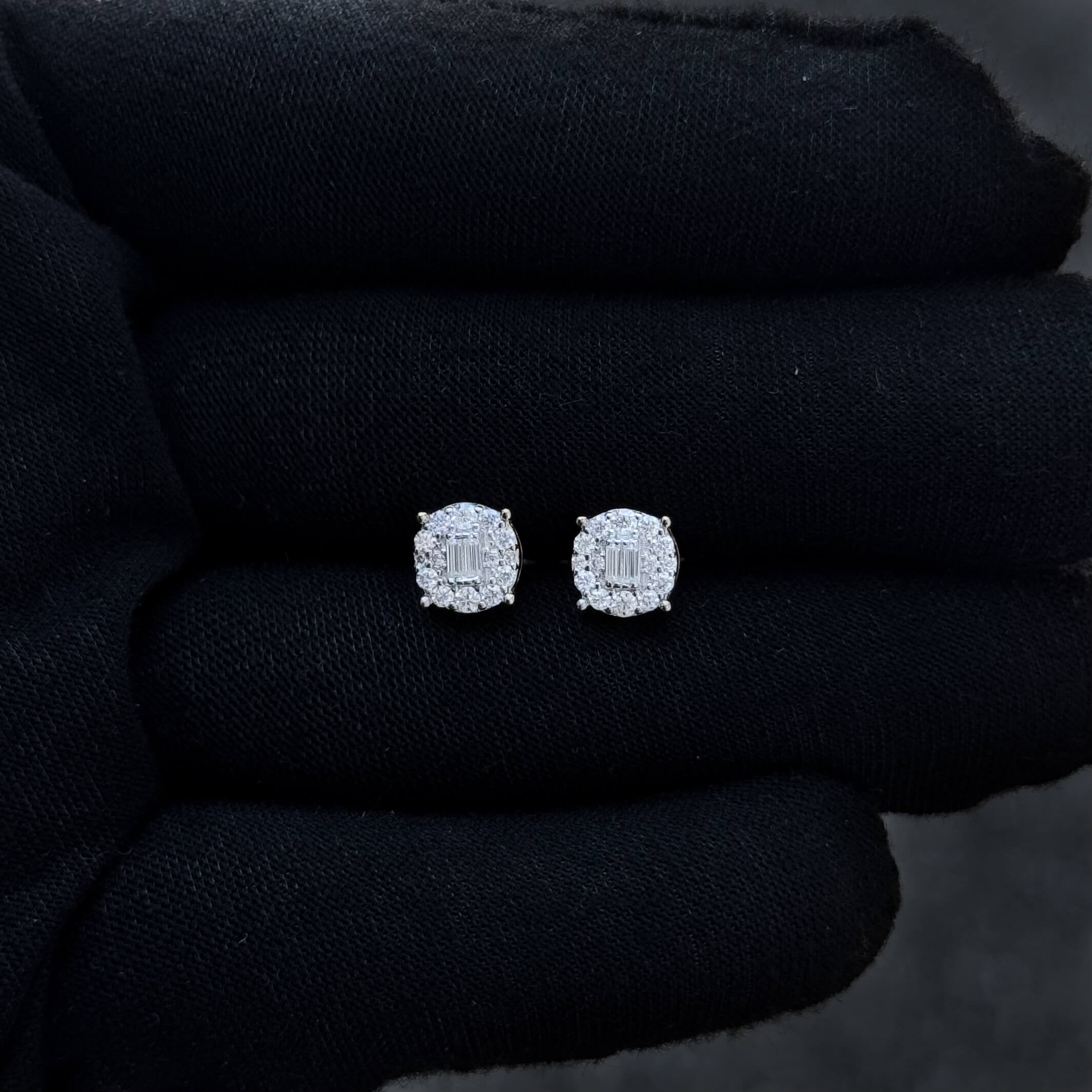 Small round 7mm moissanite diamond cluster stud earrings shown on black glove background.