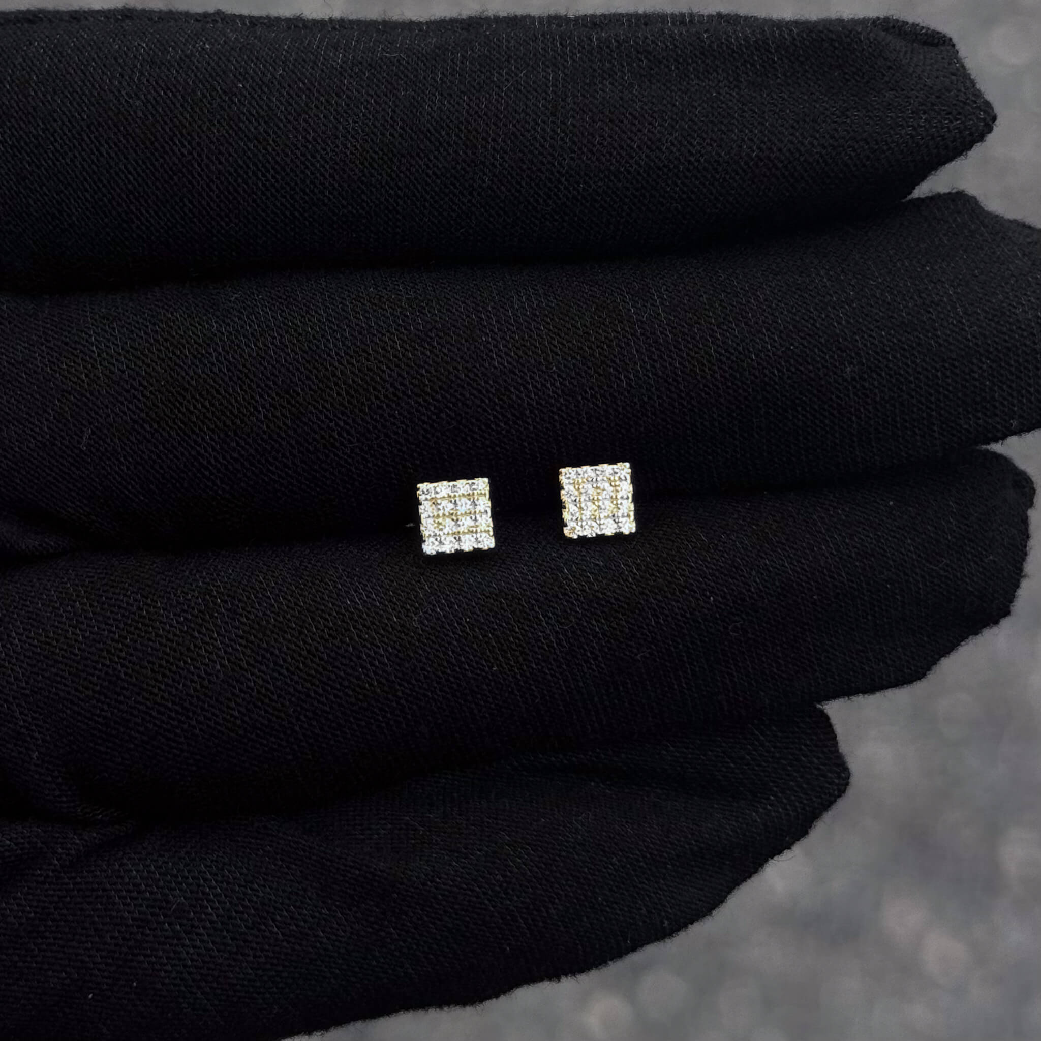 Small 5mm square Moissanite cluster diamond stud earrings in sterling silver displayed on glove.