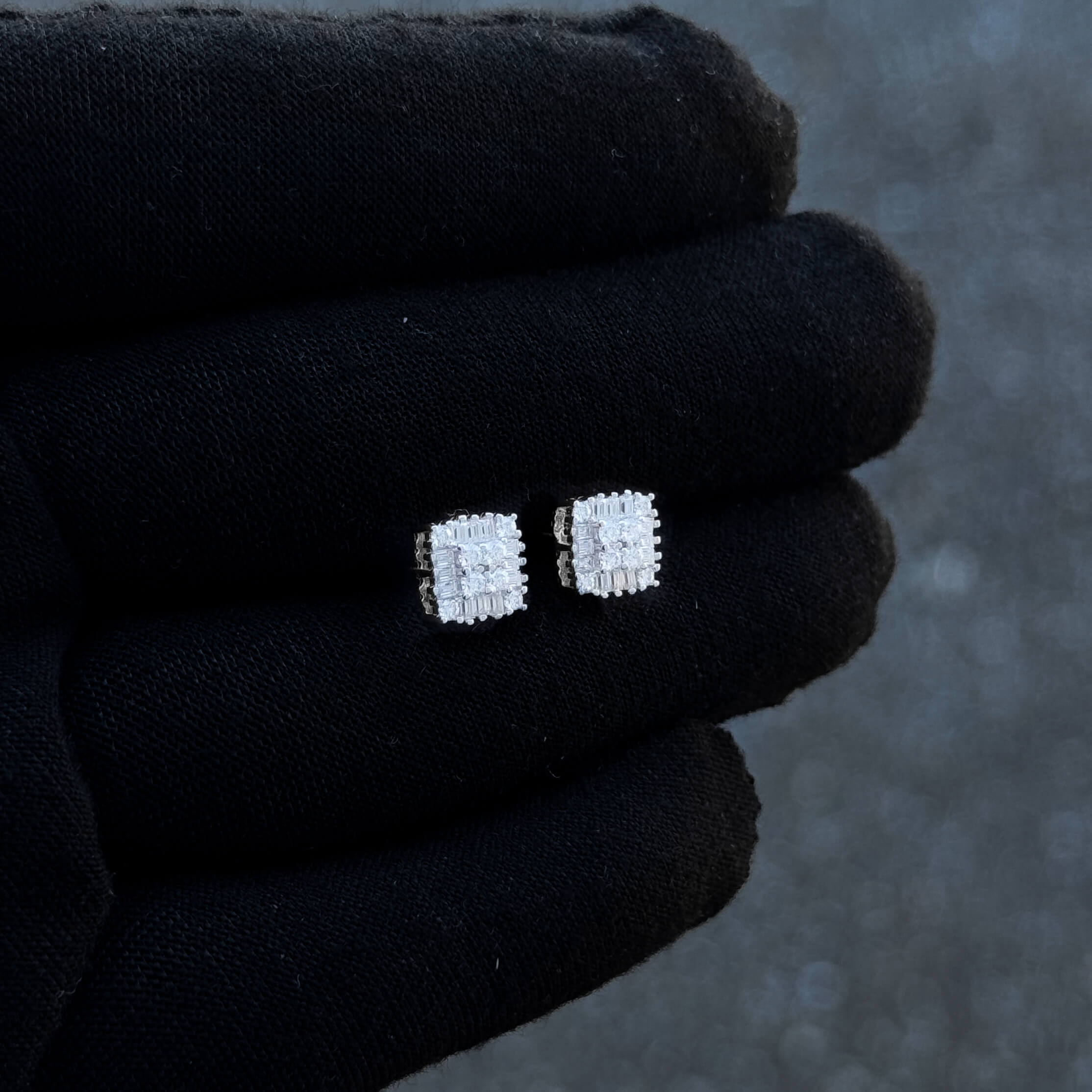 Close-up of 7mm square silver moissanite cluster stud earrings highlighting baguette design.