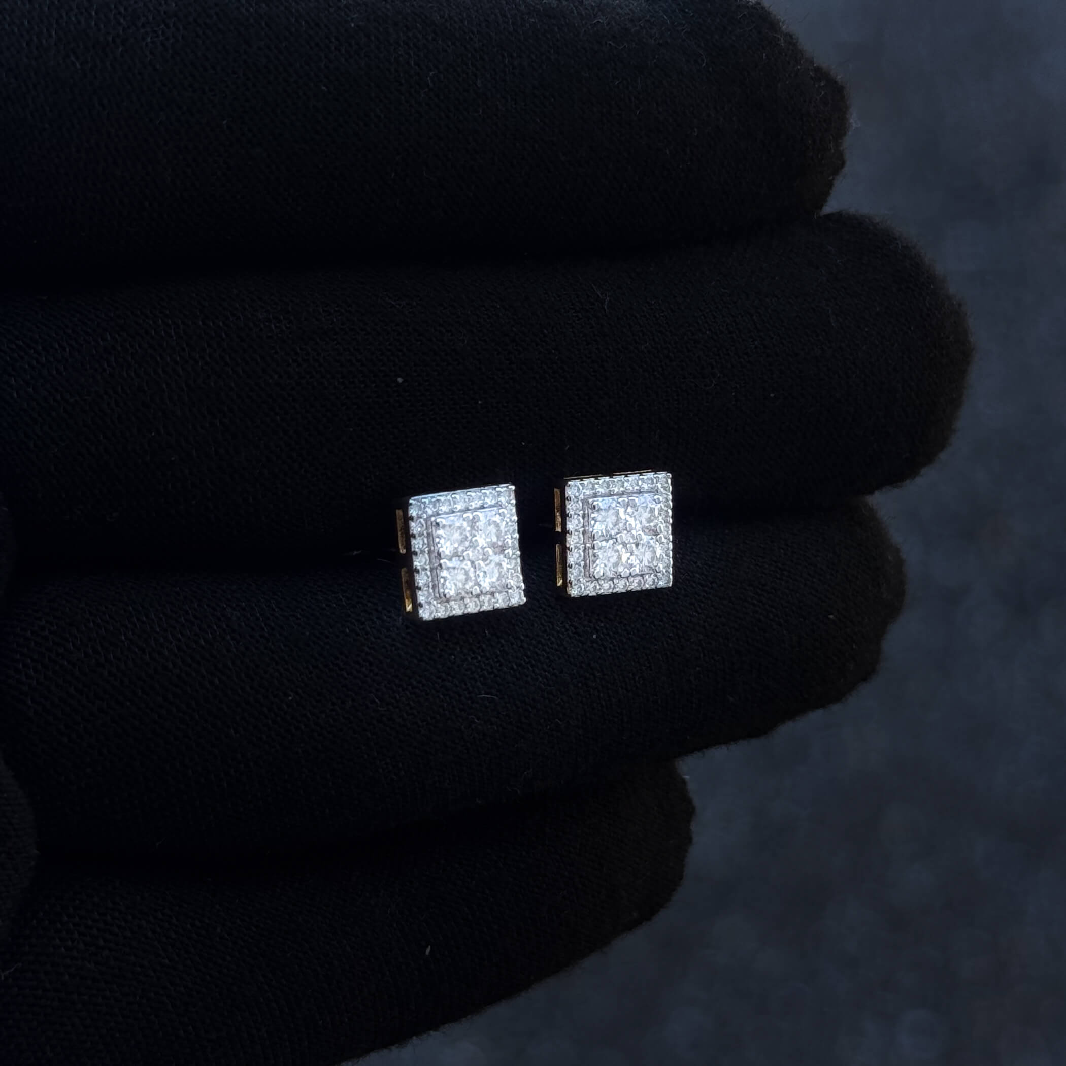 8mm square moissanite cluster diamond earrings with gold accents shown on black glove.