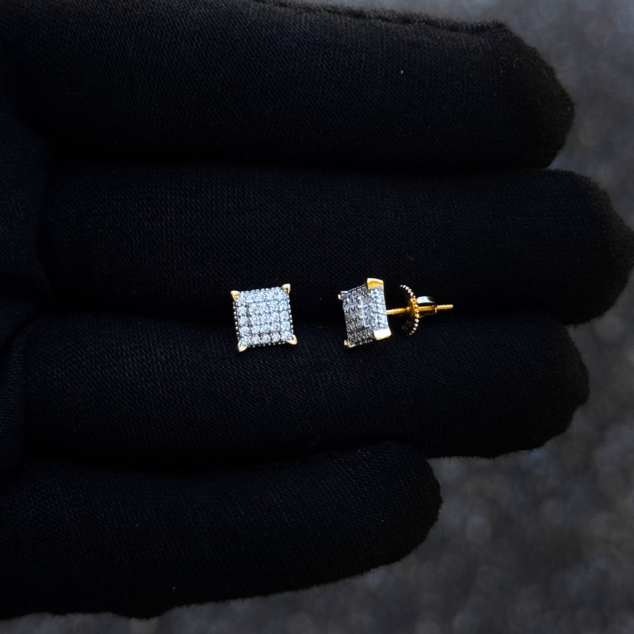 Gold-prong 7mm Moissanite cluster earrings with screw backs shown on glove for detail view.
