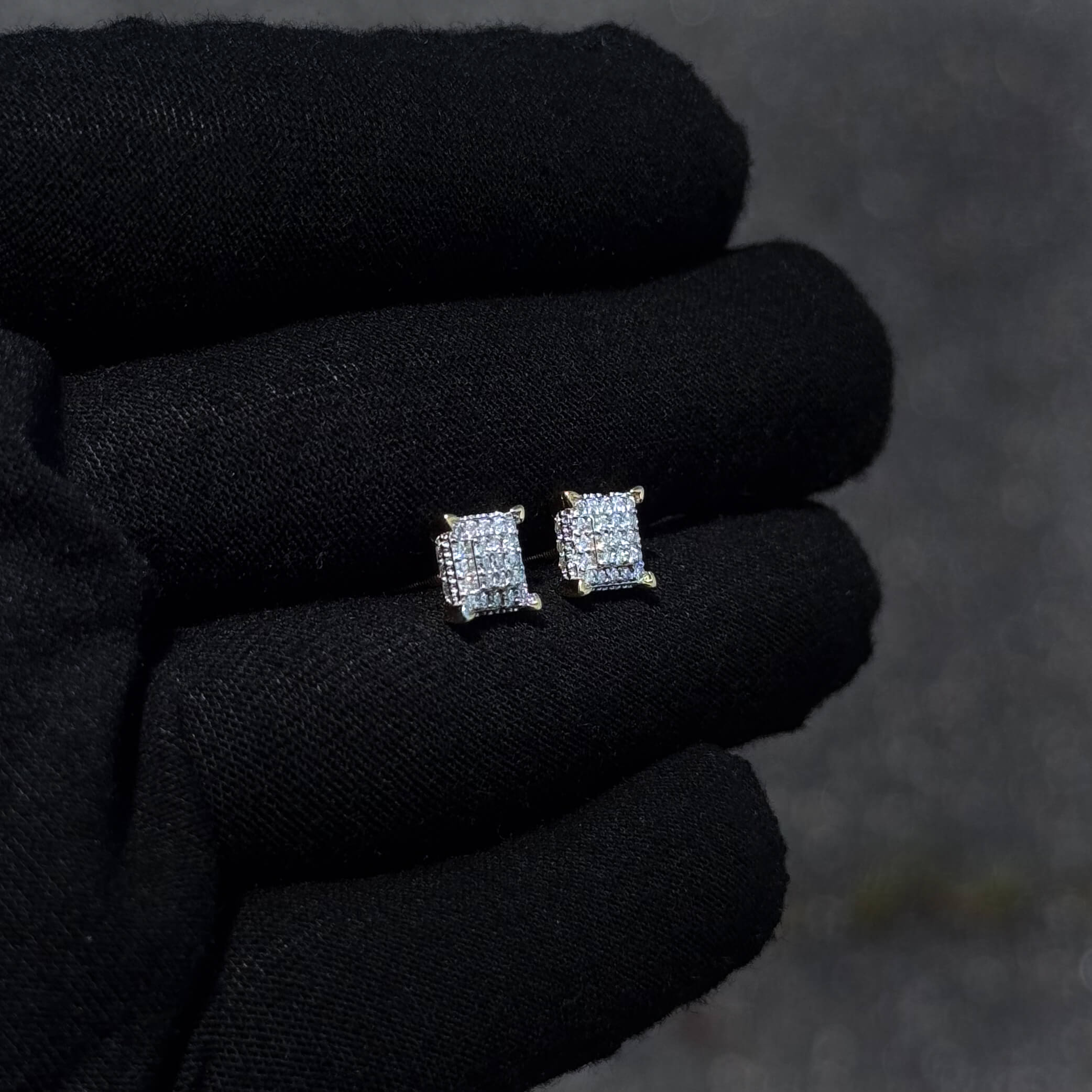 Sterling silver 7mm Moissanite cluster stud earrings displayed on glove under outdoor light.