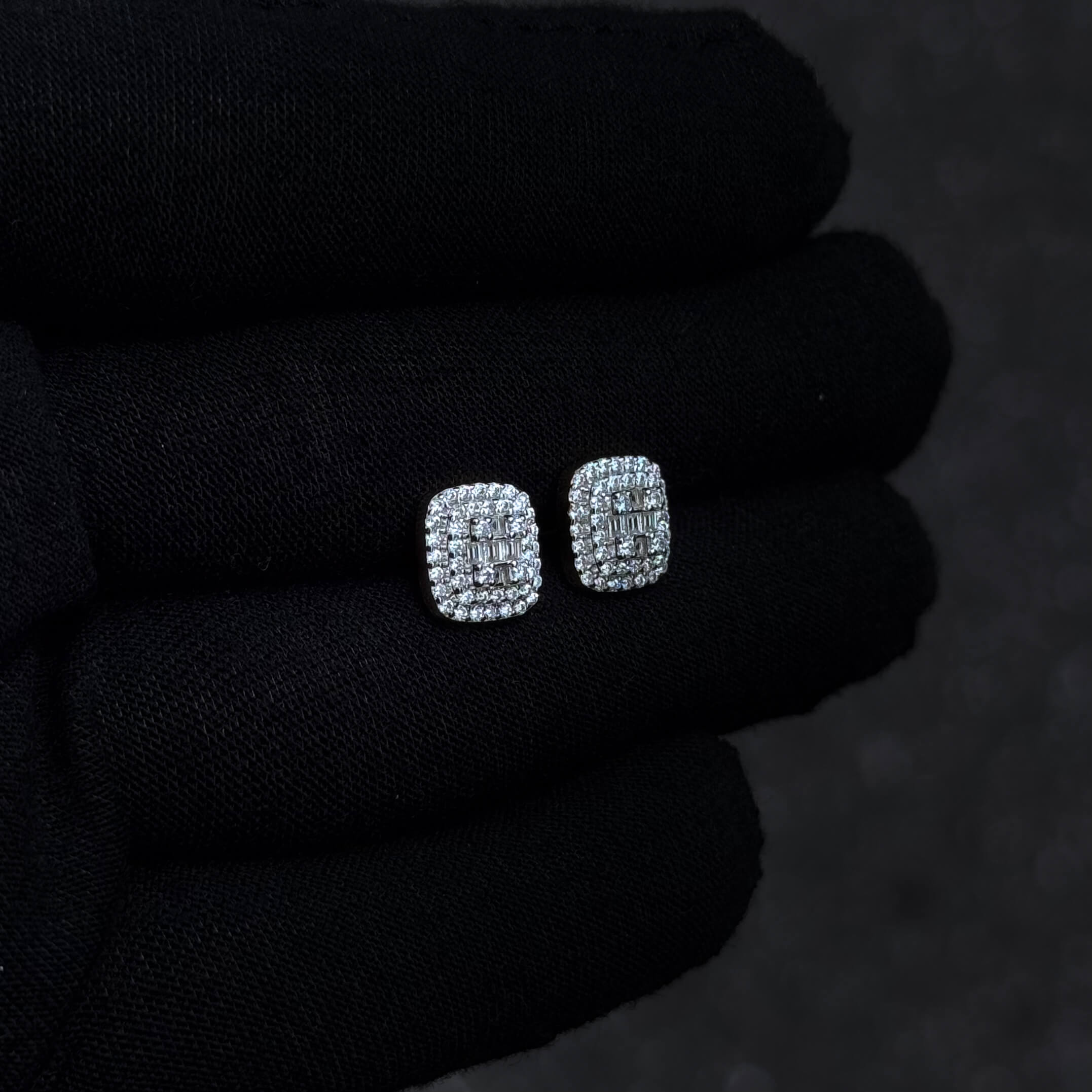 Close-up of 9mm sterling silver square moissanite stud earrings highlighting clustered stones.