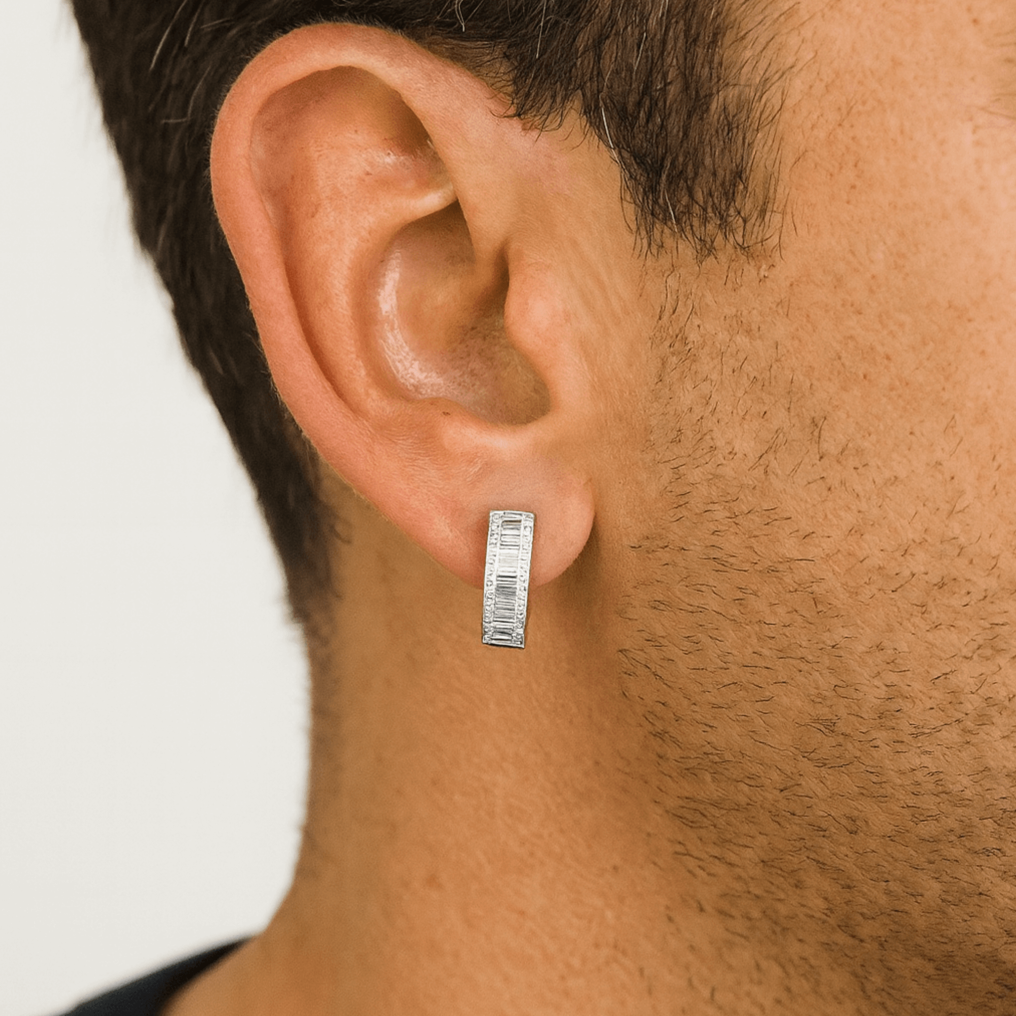 Baguette Huggie Moissanite Diamond Earring worn on ear, showcasing sleek silver hoop design.