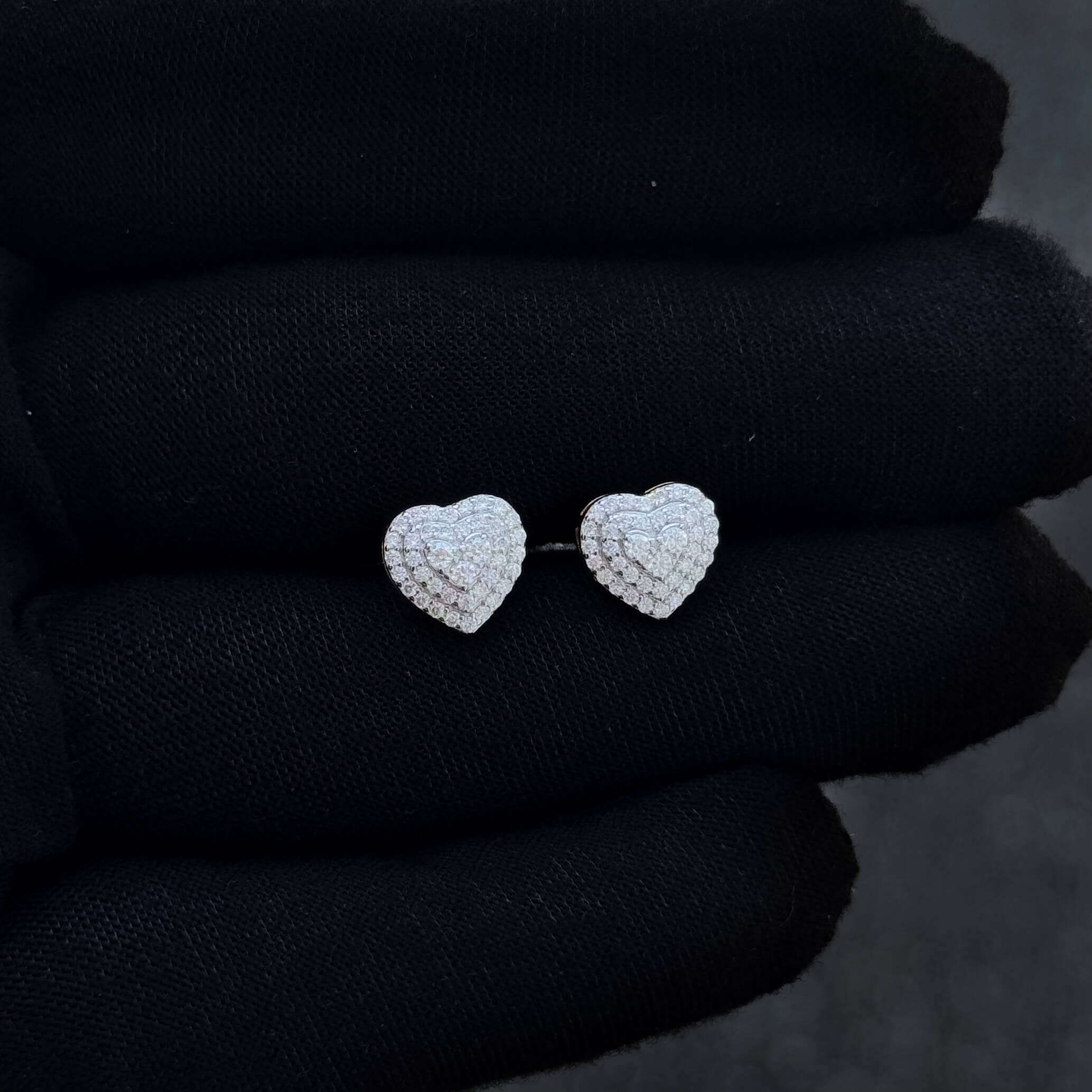 Close-up of 9mm heart moissanite cluster earrings showing layered heart halo diamond pattern.