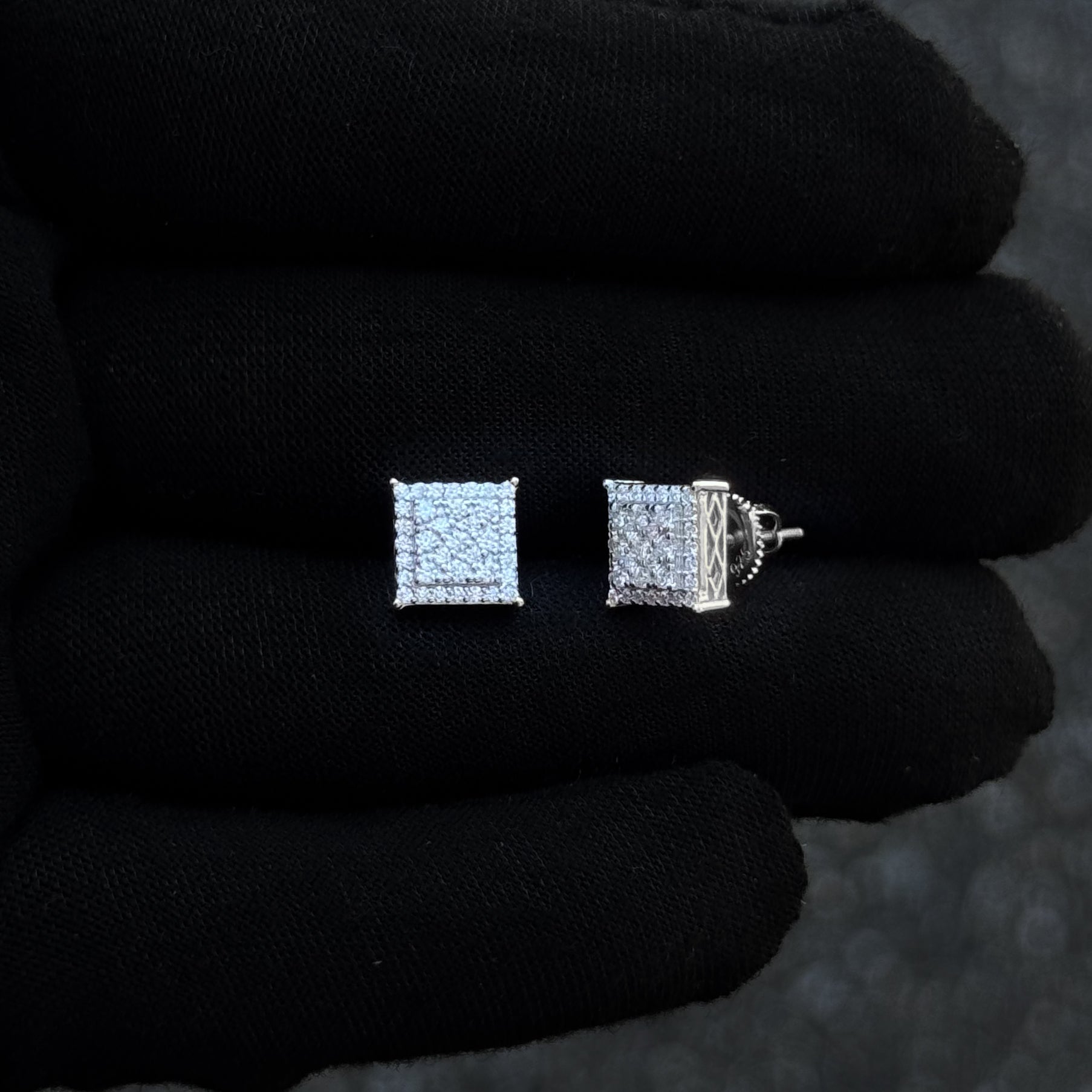 Moissanite 9mm square cluster earrings displayed on hand with detailed sterling silver sides.