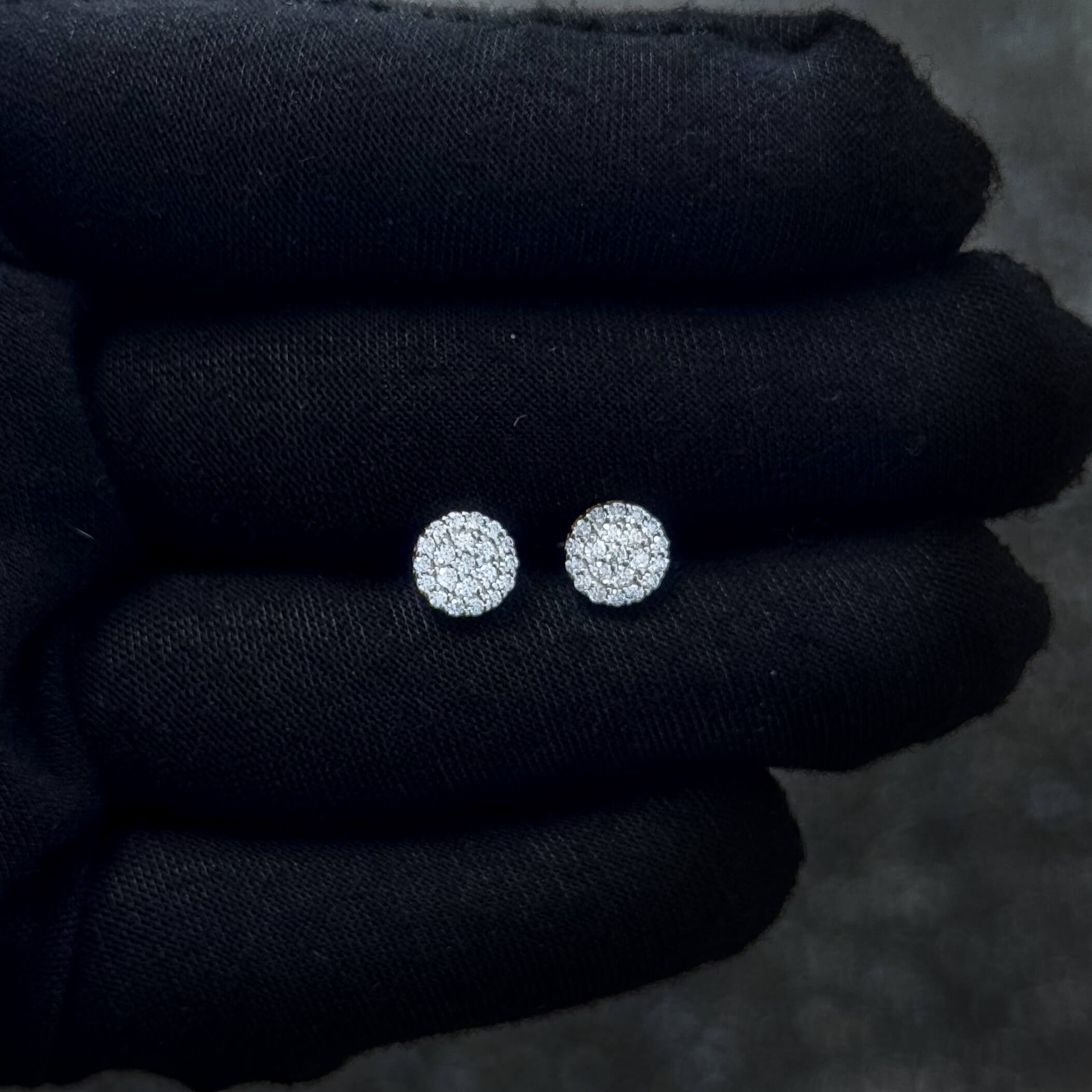 Small sterling silver Moissanite cluster stud earrings displayed on black glove for scale.