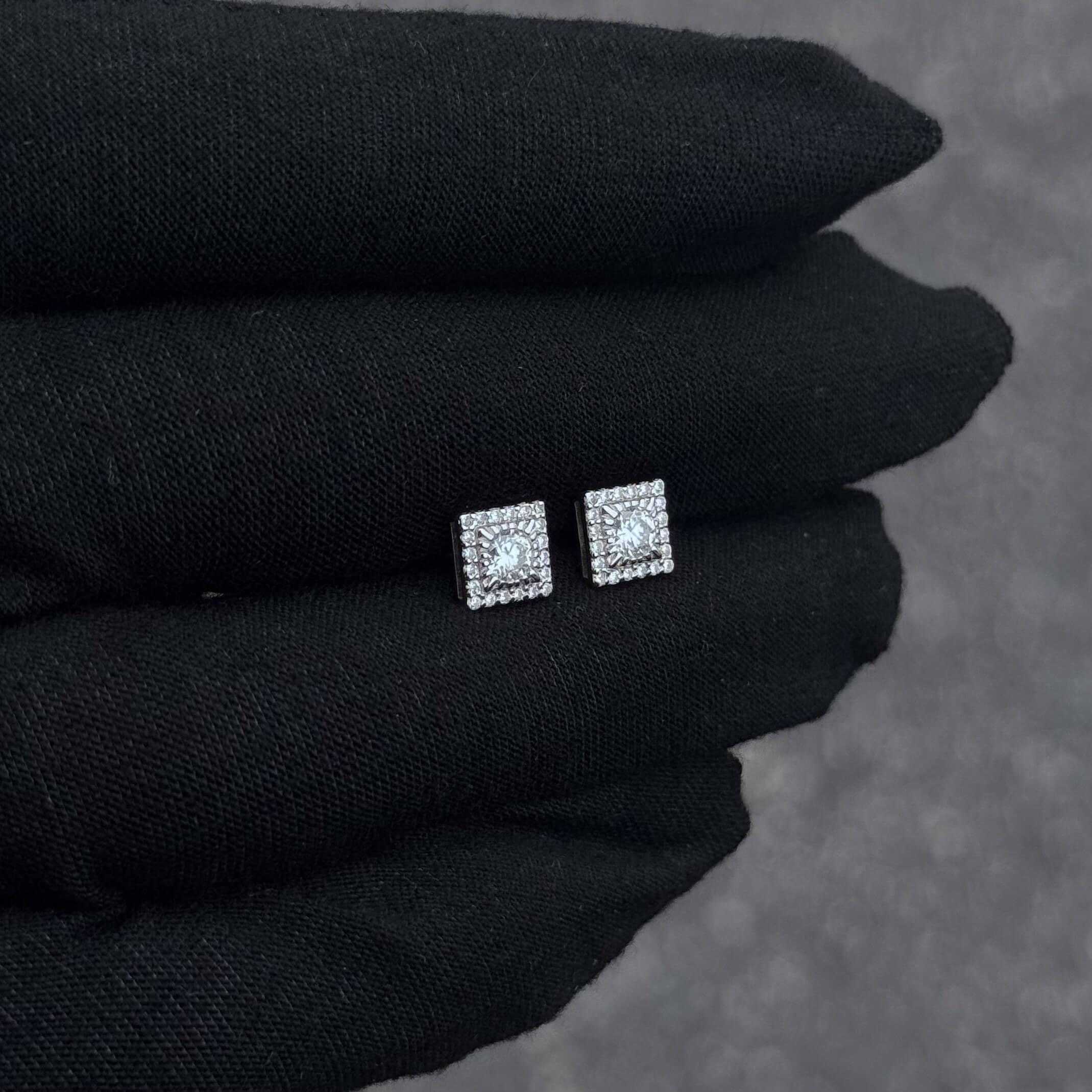 Moissanite cluster square stud earrings displayed on black glove to show shine and sterling finish.