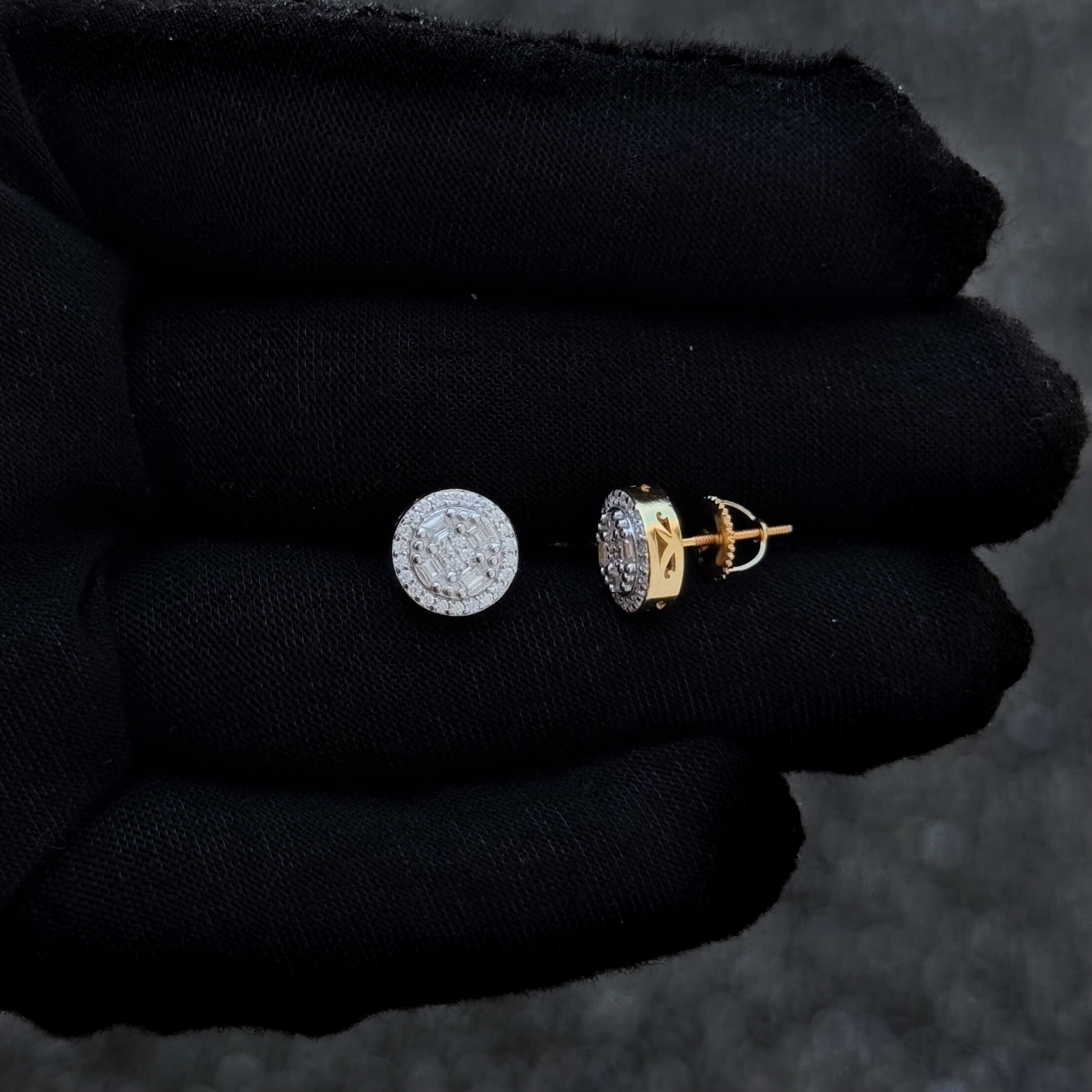 Moissanite round cluster diamond studs with gold screw-back posts shown on black glove.