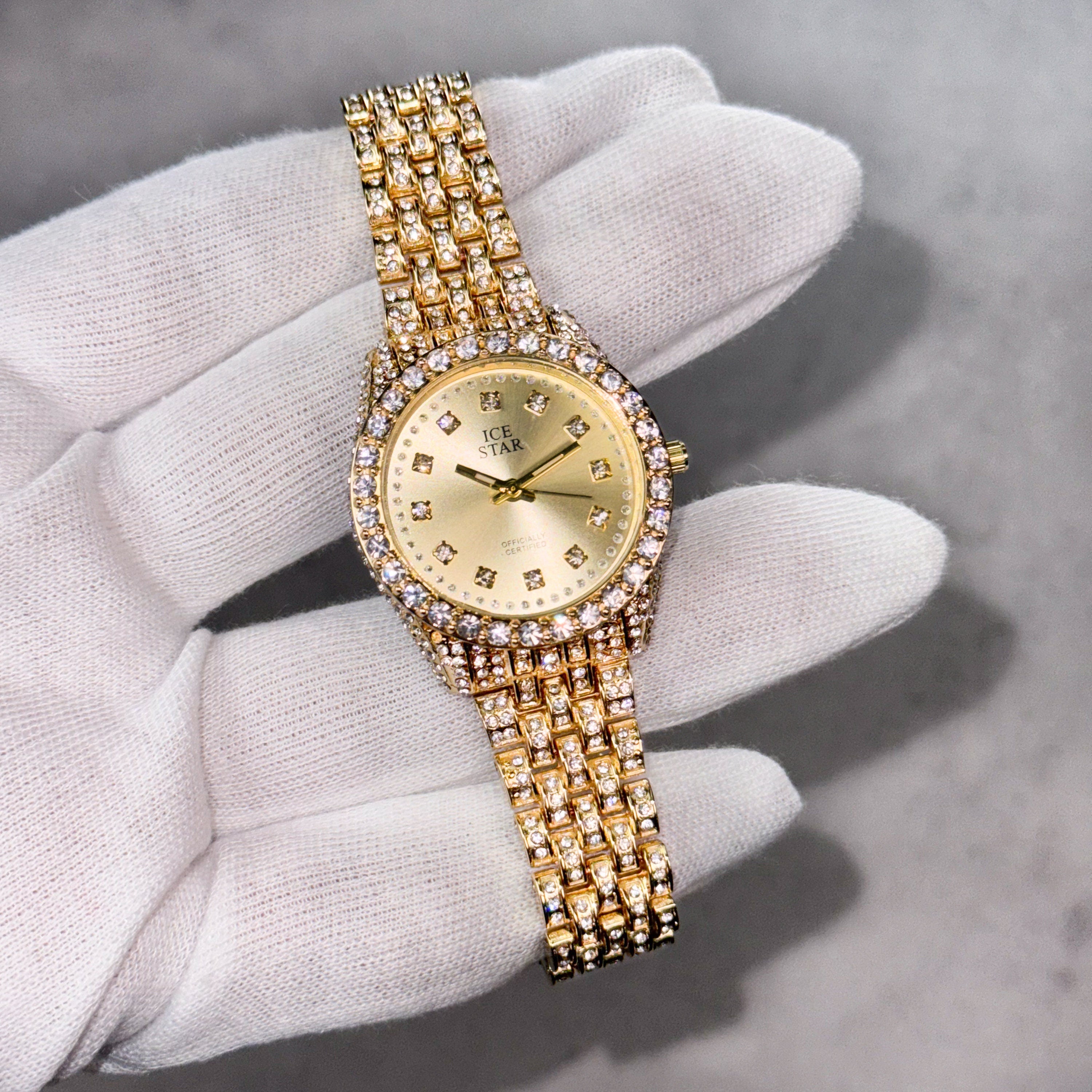 Gold Women's 32mm diamond watch with blinged-out bezel, sleek gold dial and crystal bracelet.