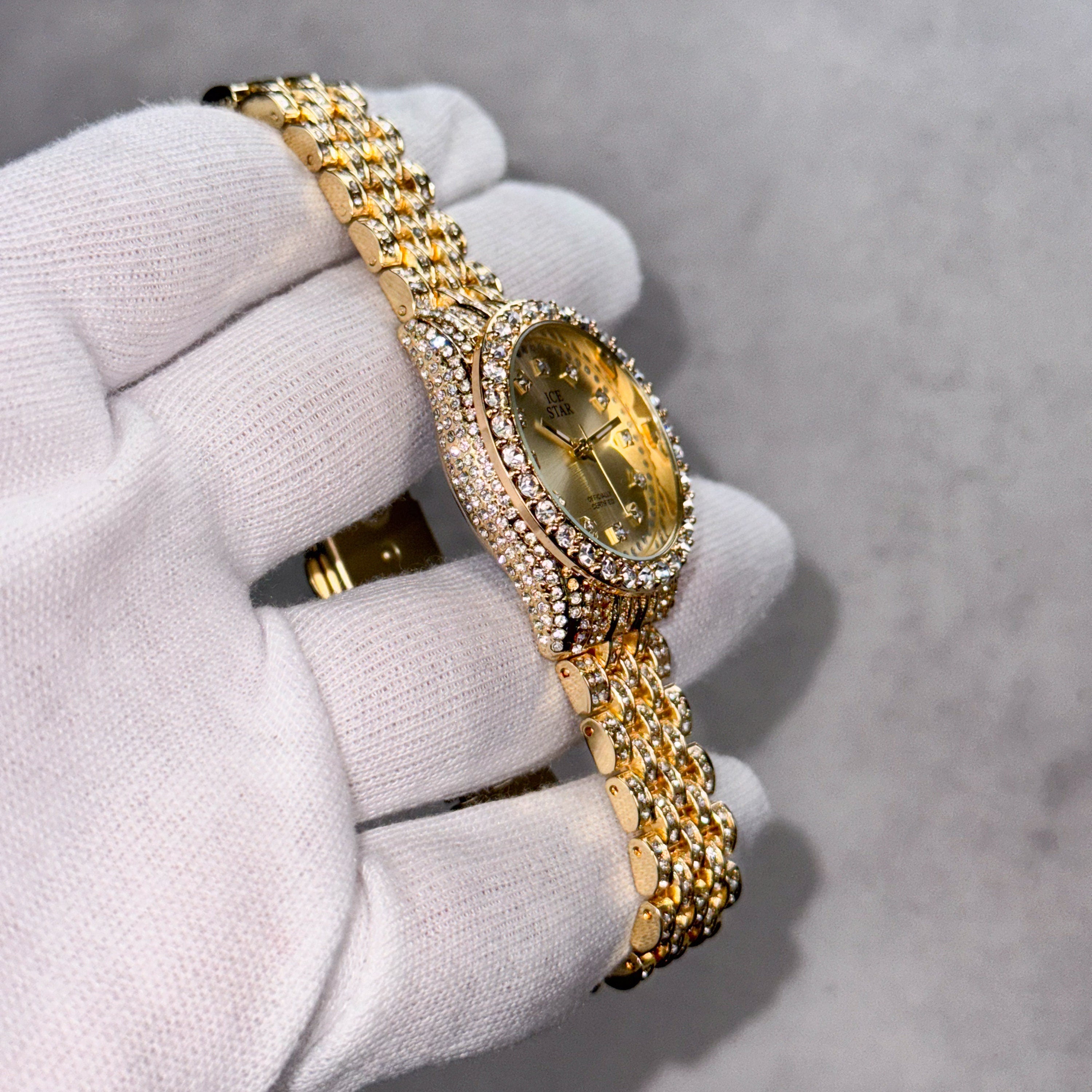 Side view of gold Women's 32mm diamond watch featuring iced bezel and multi-row crystal band.