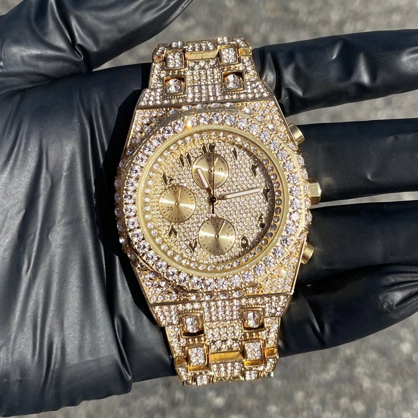 Gold men’s 43mm luxury iced out watch featuring an octagon bezel, Arabic dial, and fully iced band.