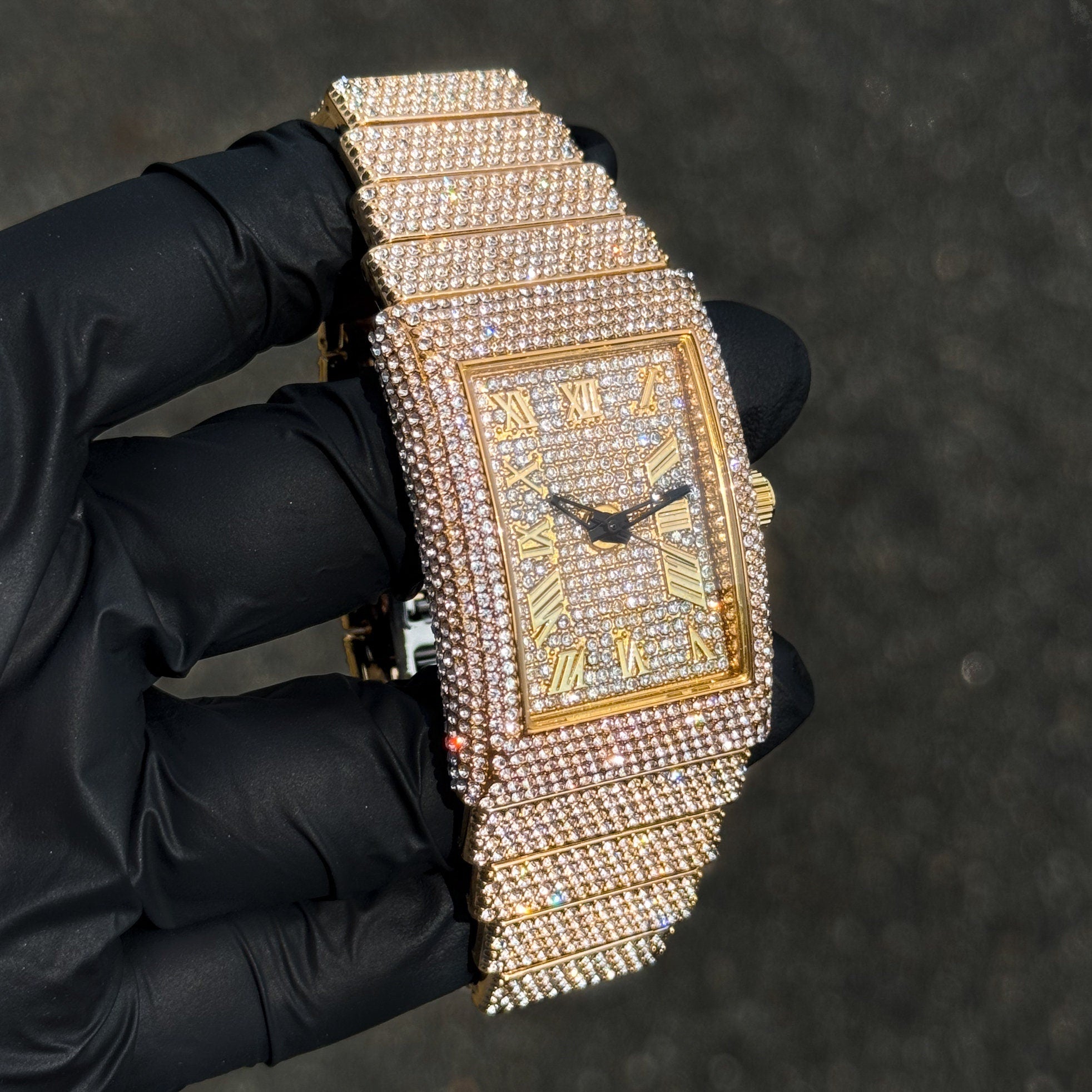 Women's gold 33mm iced-out diamond watch featuring a rectangular dial and layered band.