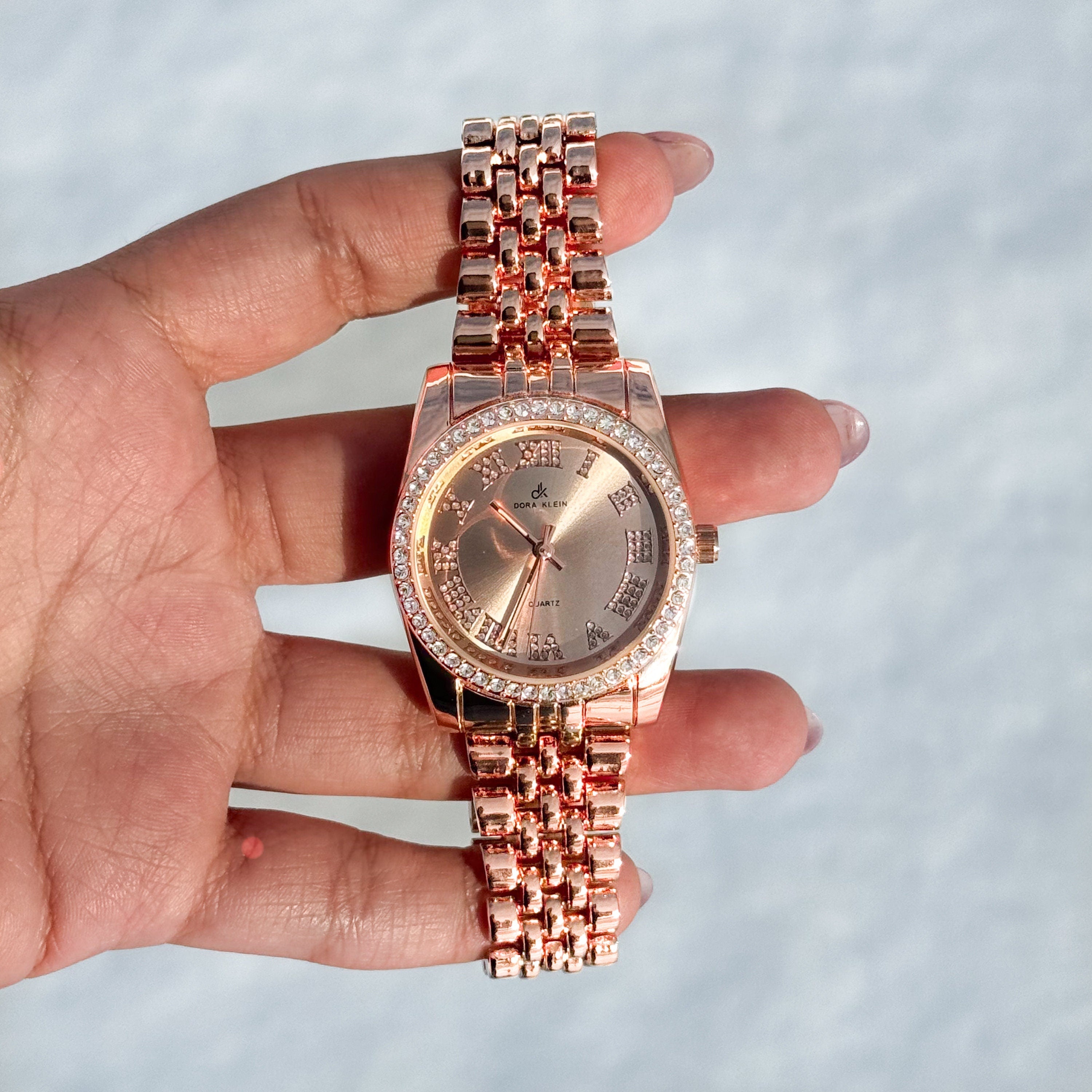 Rose gold Women's 35mm metal band watch with Roman numeral dial and sparkling crystal bezel.