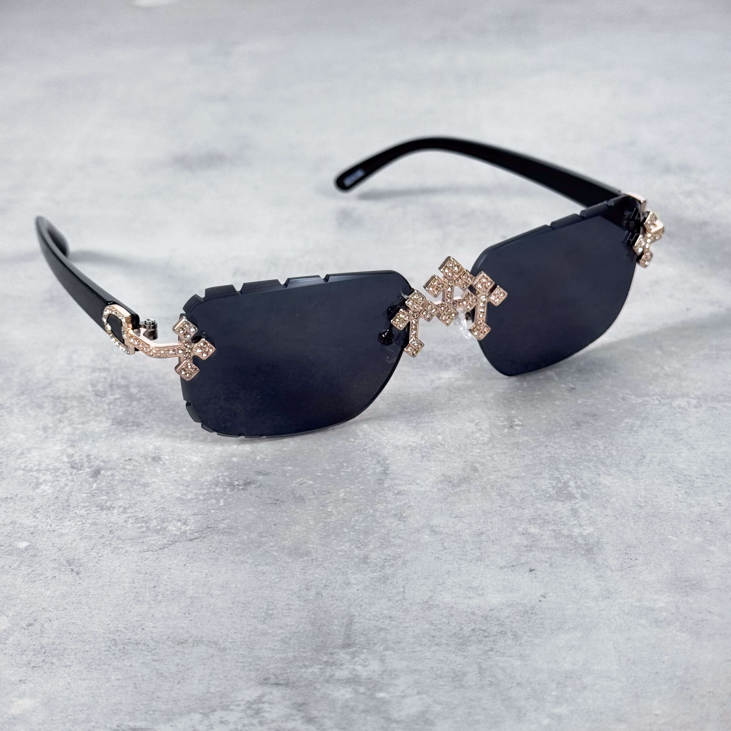 Rimless black lens triple cross sunglasses featuring gold iced cross details and sleek arms.