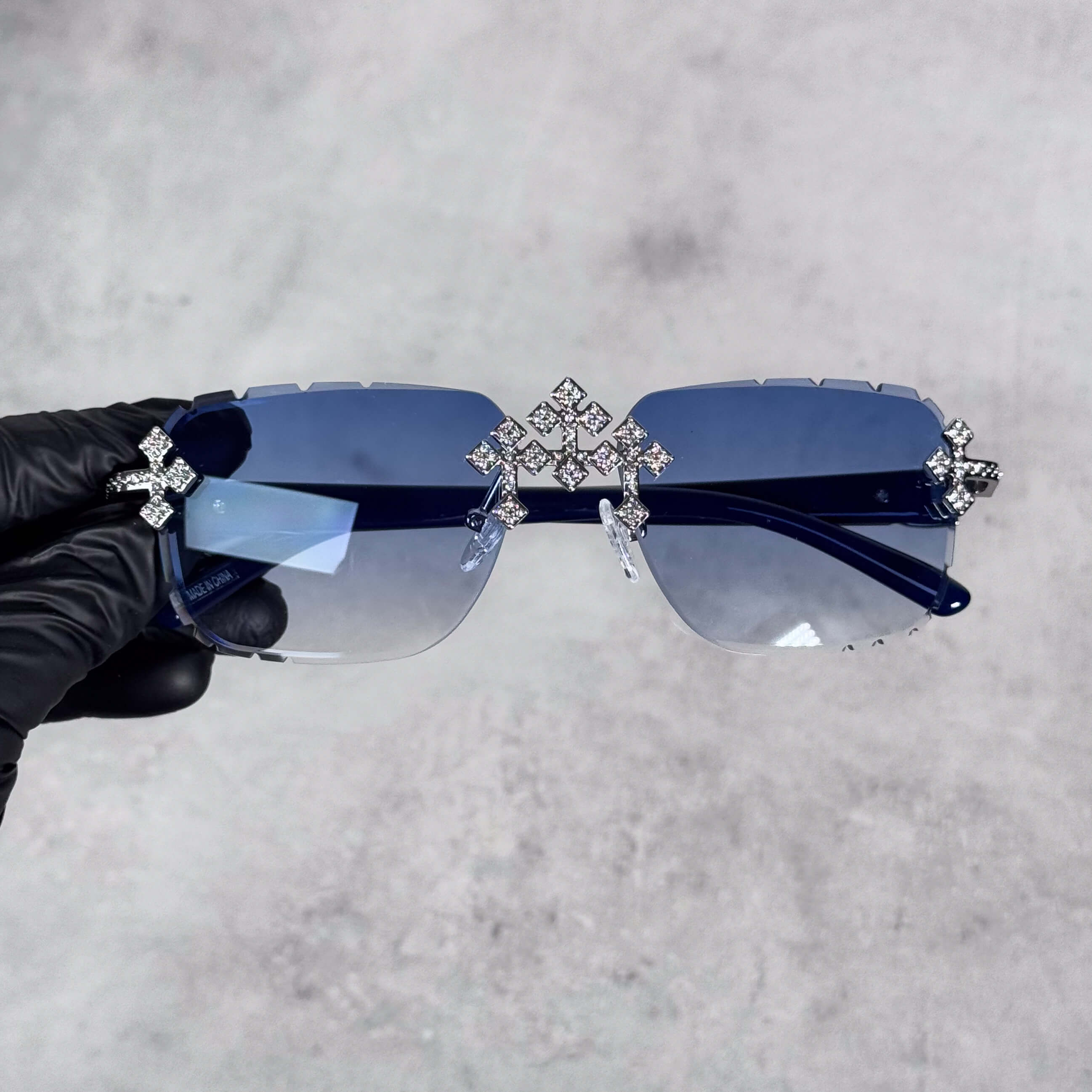 Blue lens Iced Triple Cross Sunglasses featuring rimless design and sparkling crystal cross details.