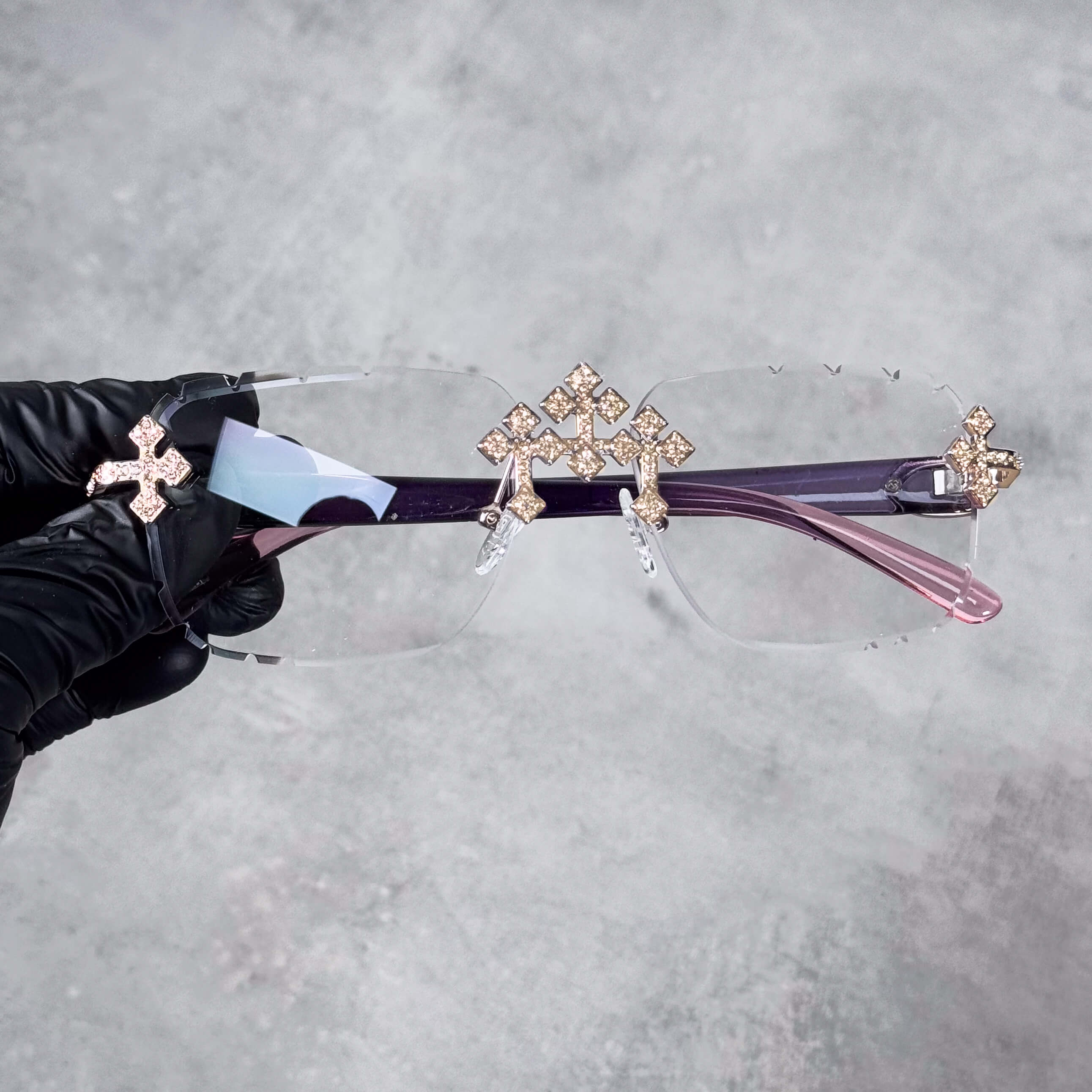 Iced Triple Cross Sunglasses in clear lens design with gold-tone crystal crosses and purple arms.