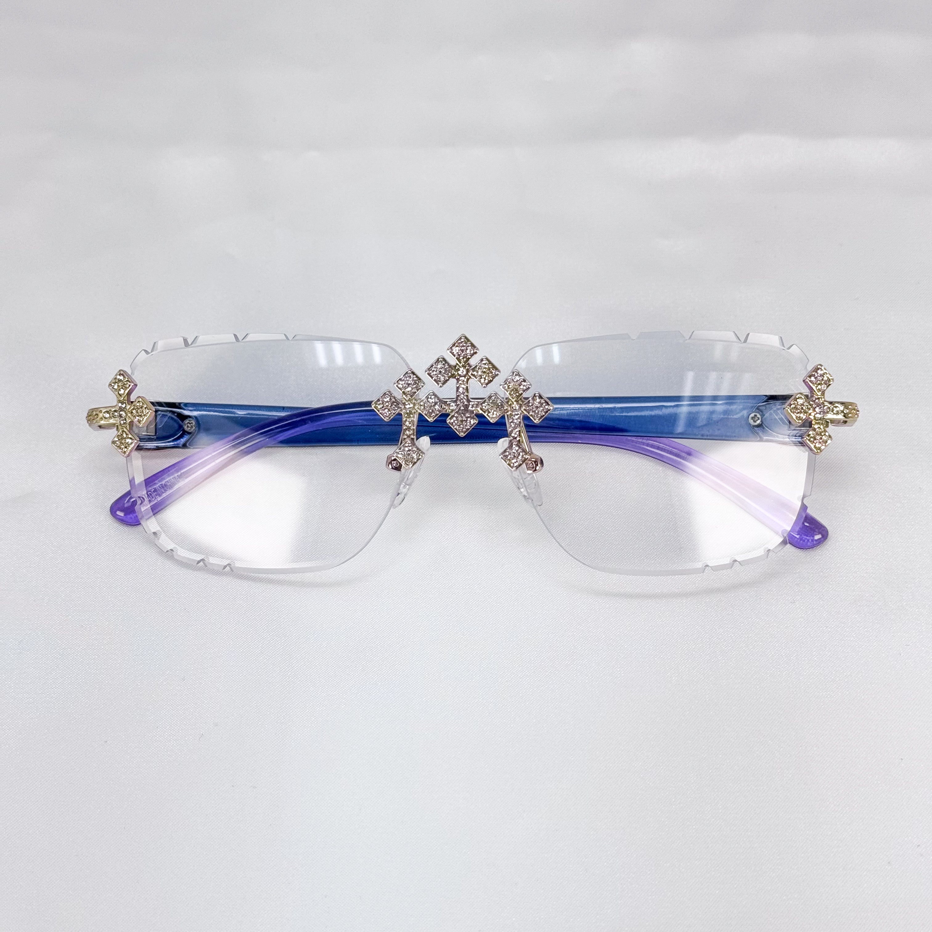 Crystal-studded Triple Cross Sunglasses with clear rimless lenses and purple gradient temples.