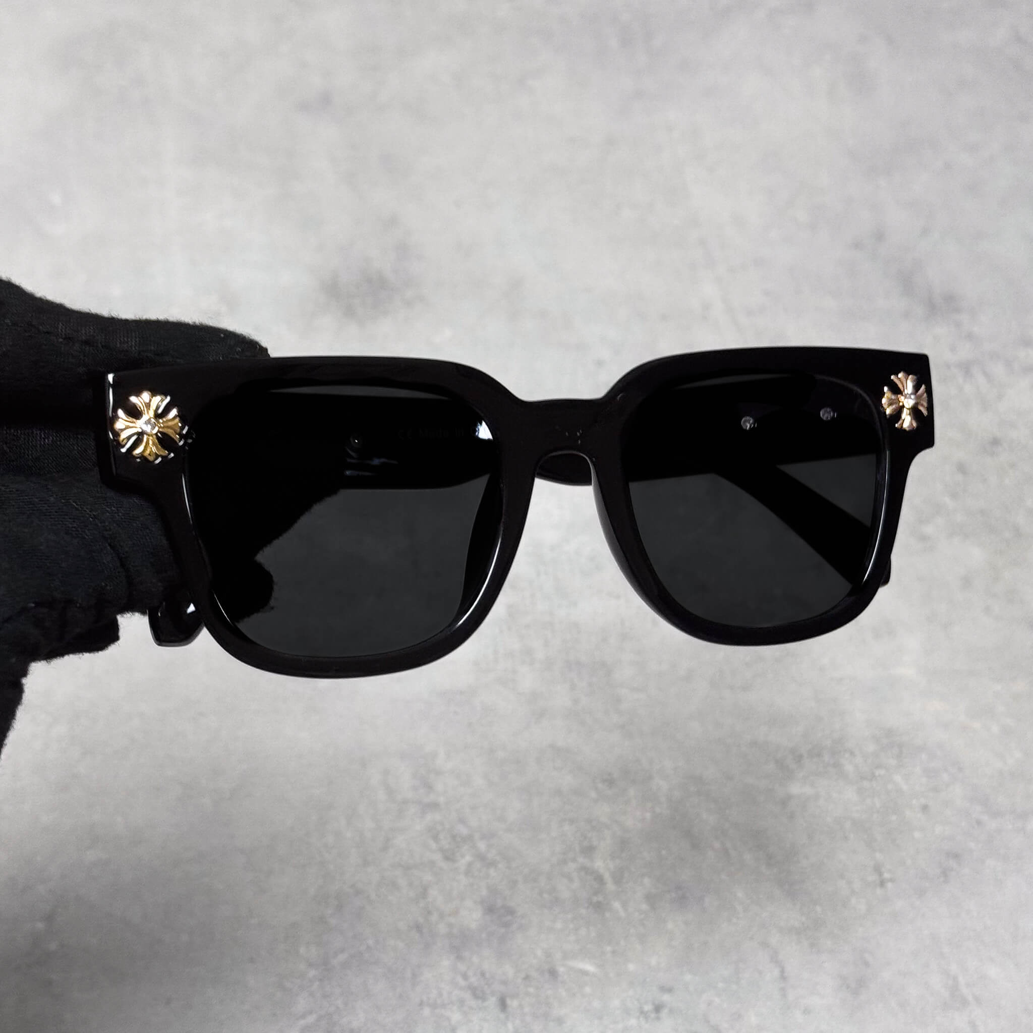 Front view of Cross Chrome Inspired Sunglasses featuring glossy black frame and gold cross details.
