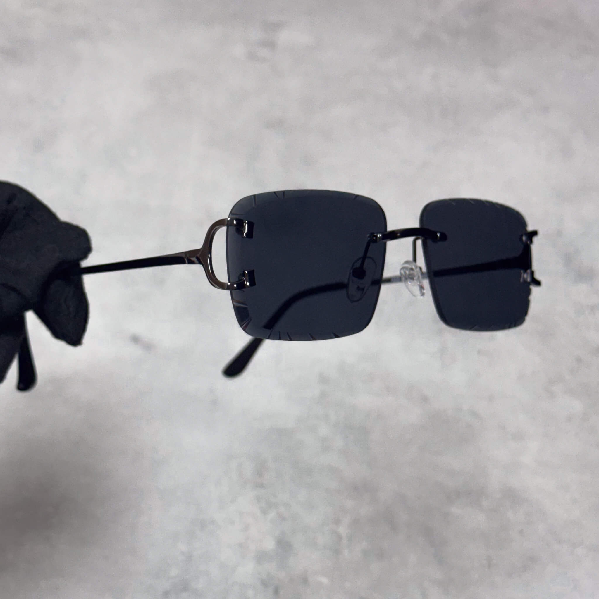 Black lens Solid Cut-Edge Sunglasses with slim black temples and square rimless design.
