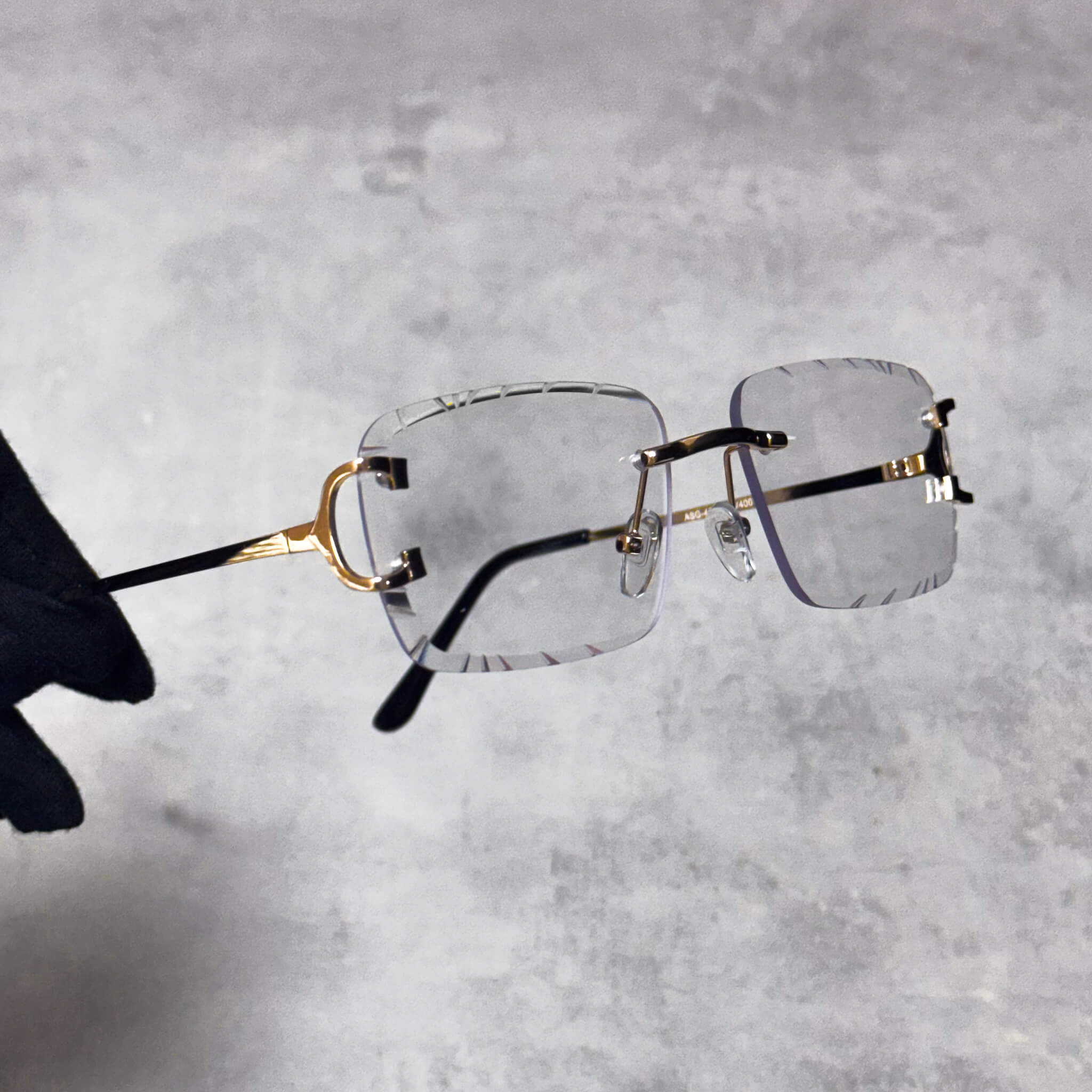 Rimless clear-lens Solid Cut-Edge Sunglasses with gold temples and square cut edges.