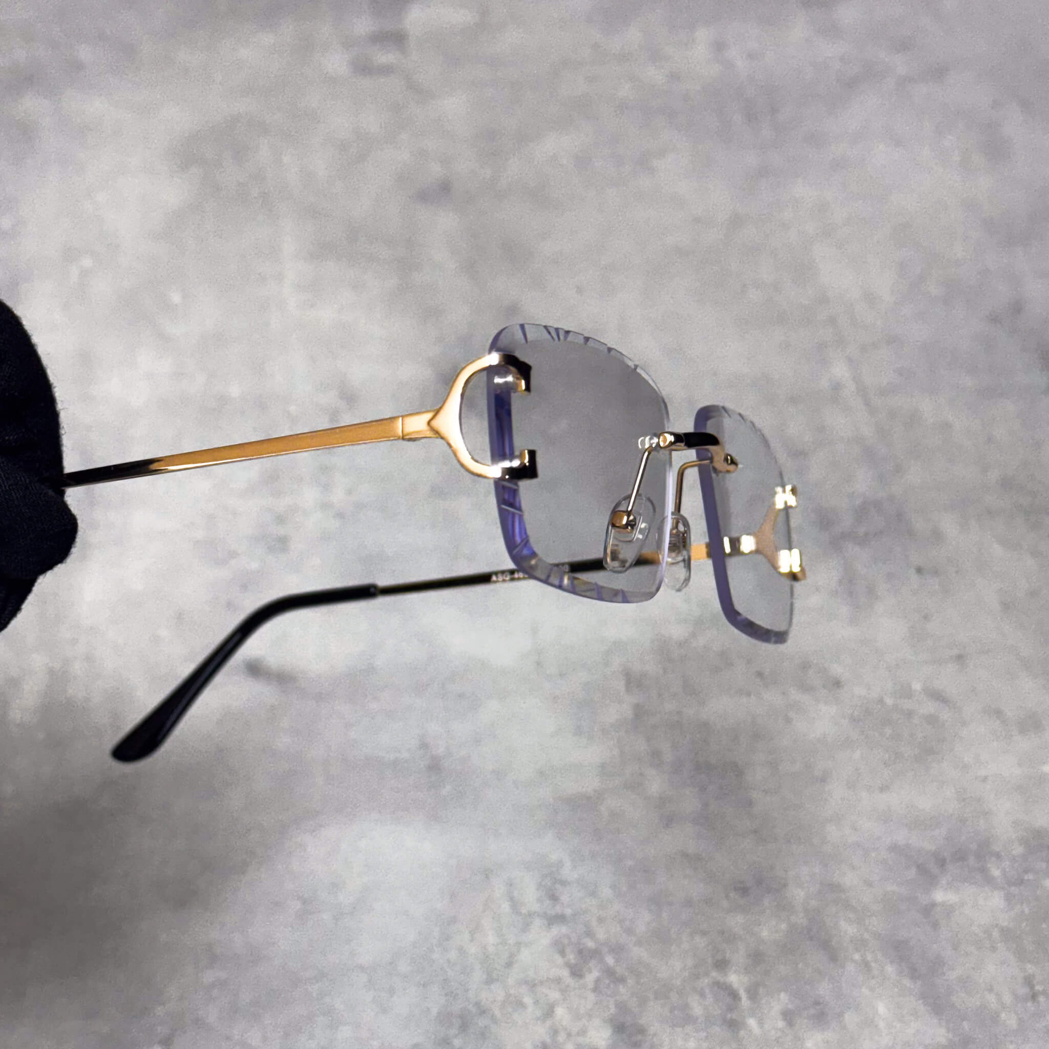 Side view of clear-lens Solid Cut-Edge Sunglasses with gold metal temples and cut edges.