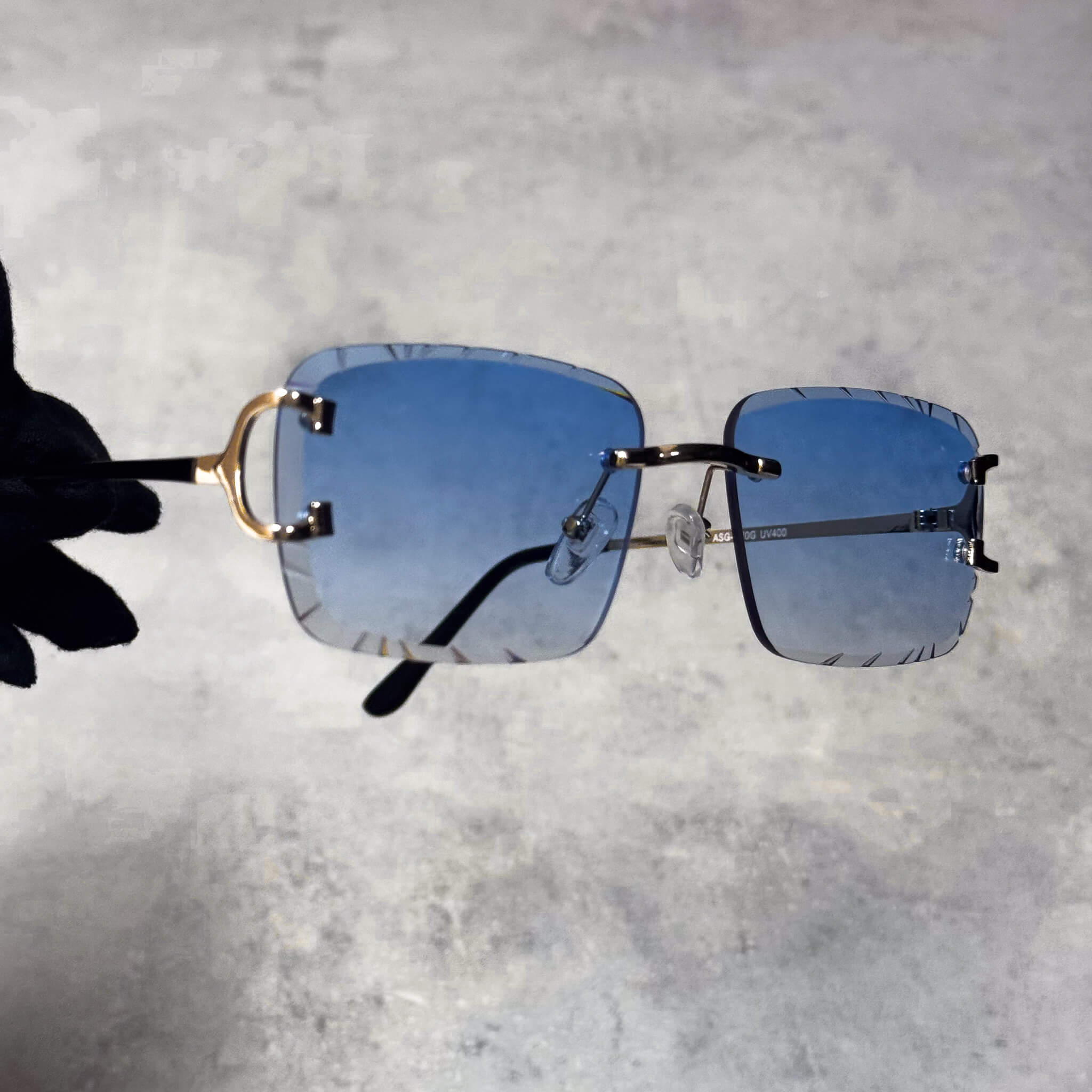 Rimless blue Solid Cut-Edge Sunglasses with gold hinge accents and sleek square lens edges.