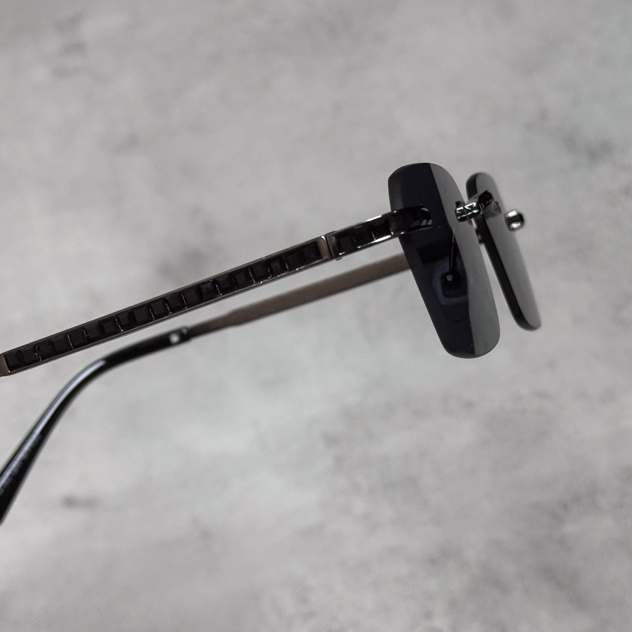 Side view of black lens baguette stone sunglasses featuring detailed black arm accents.