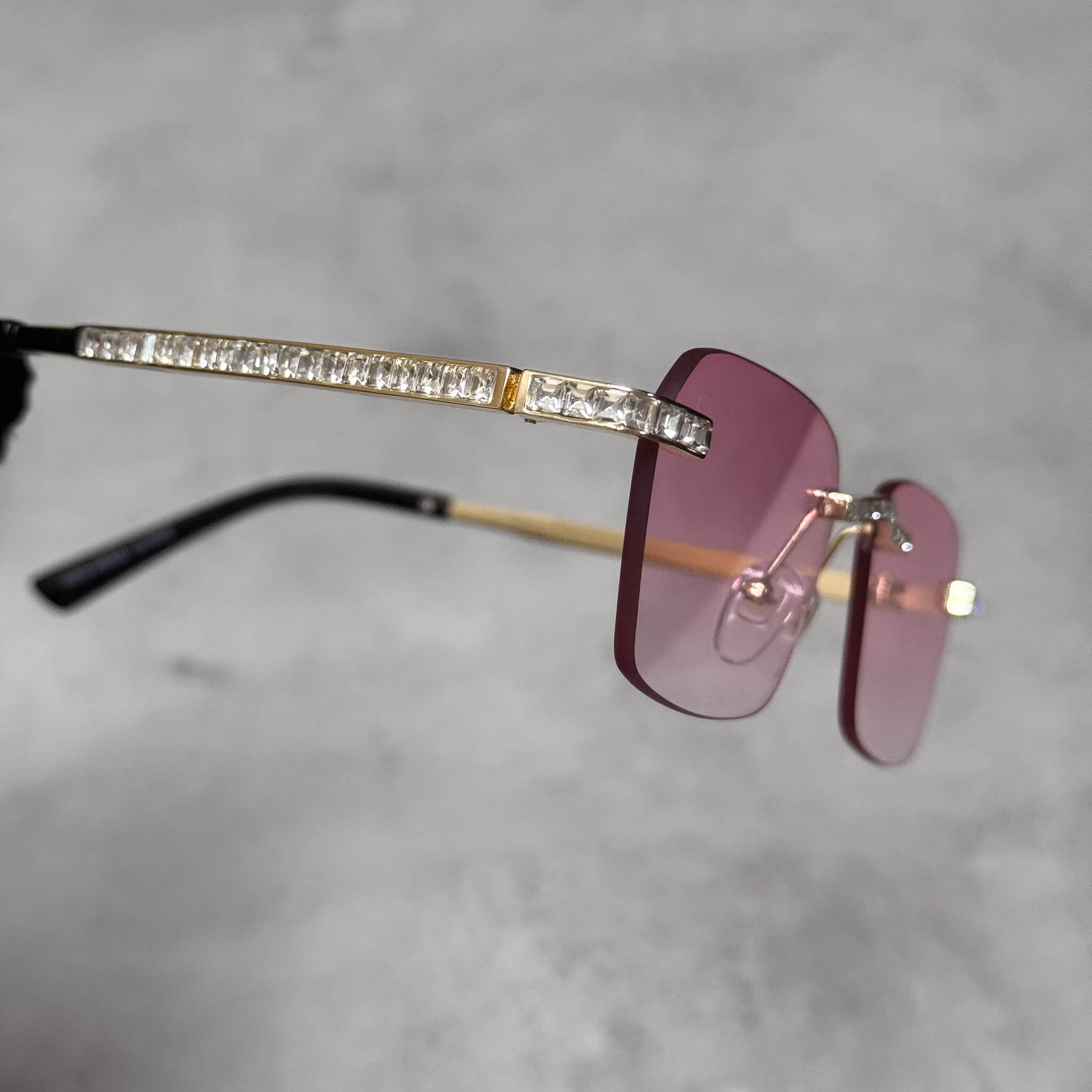 Pink lens Baguette Stone Sunglasses featuring gold rimless frame and crystal-lined temple arms.