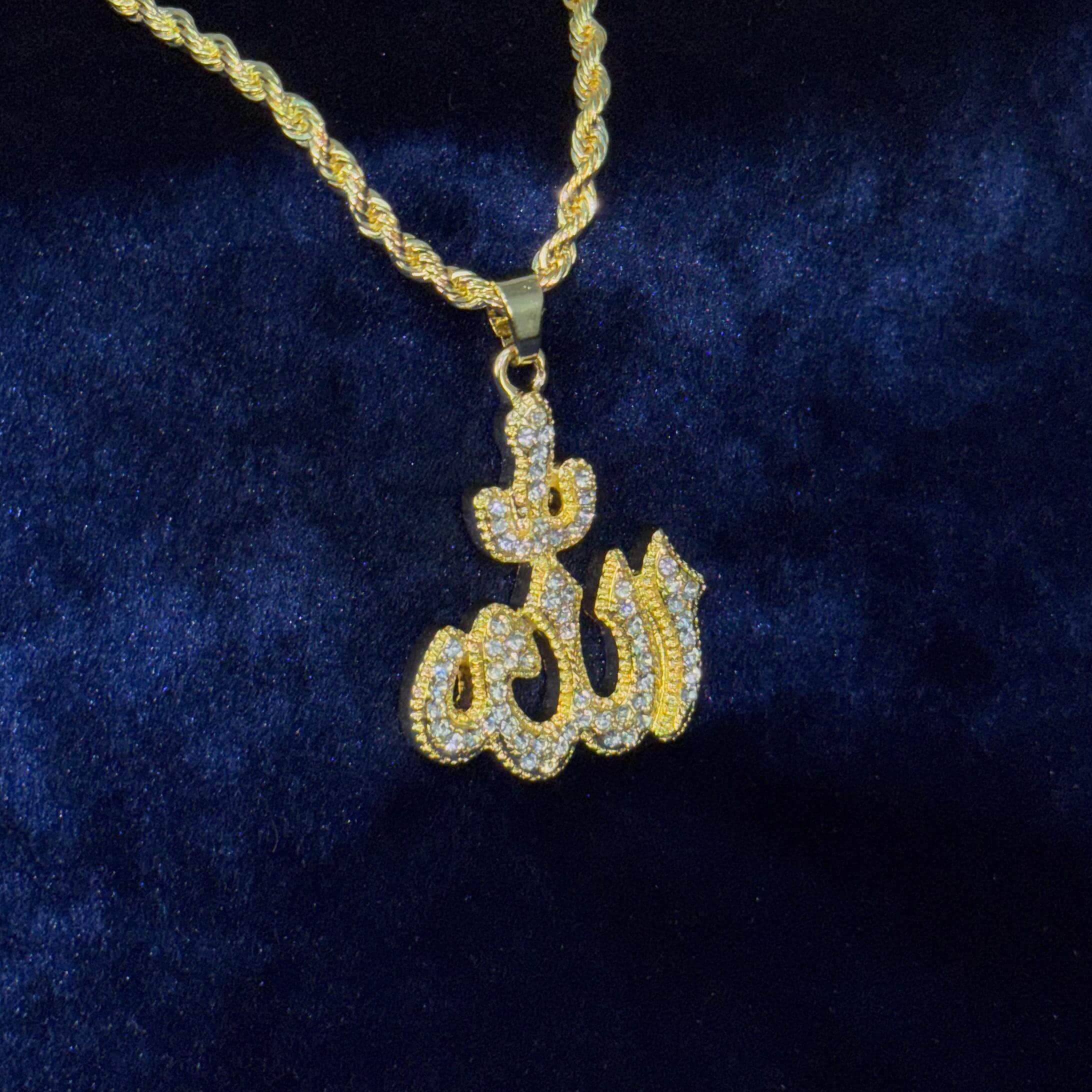 Close-up of gold 26mm iced-out Allah pendant on 5mm rope chain displayed against blue velvet.