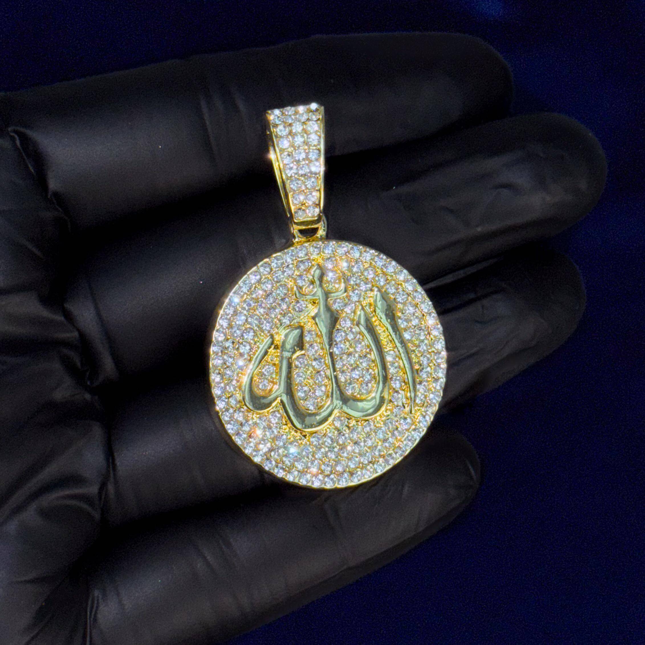 Close-up gold 22mm iced-out medallion Allah pendant with pavé stones held in gloved hand.