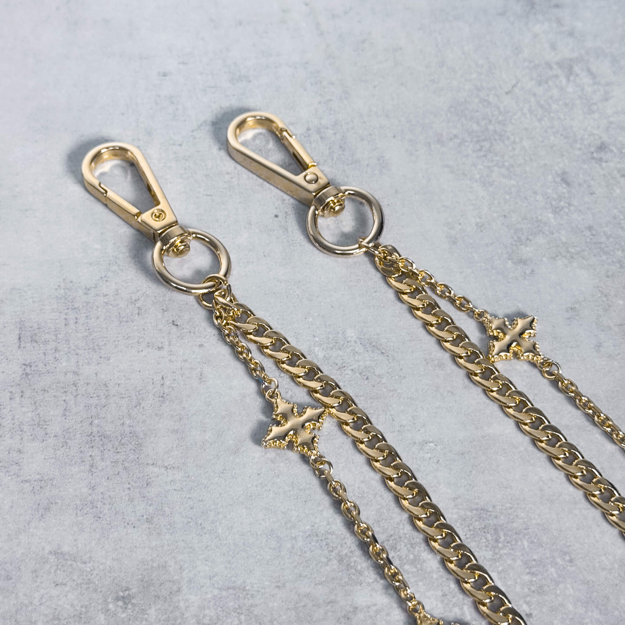 Close-up of gold Cuban with Cross Pant Chain showing layered links and cross-style charms.
