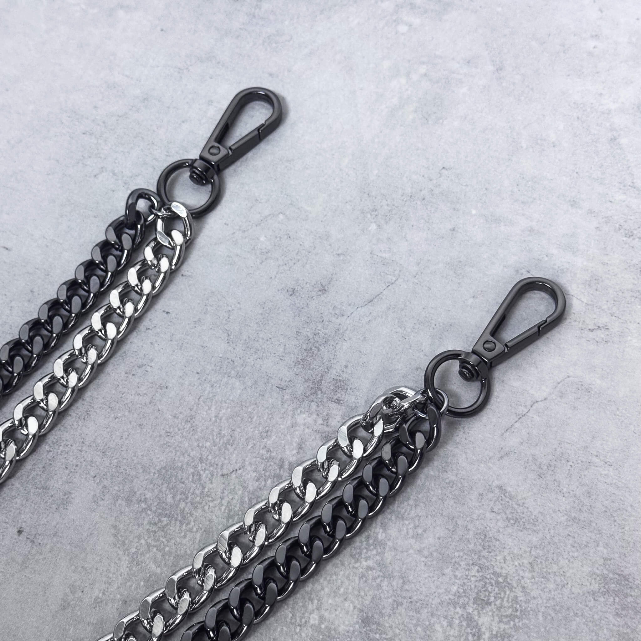 Close-up of Duo Cuban Chain Link Pant Chain clasps in two-tone silver and black.