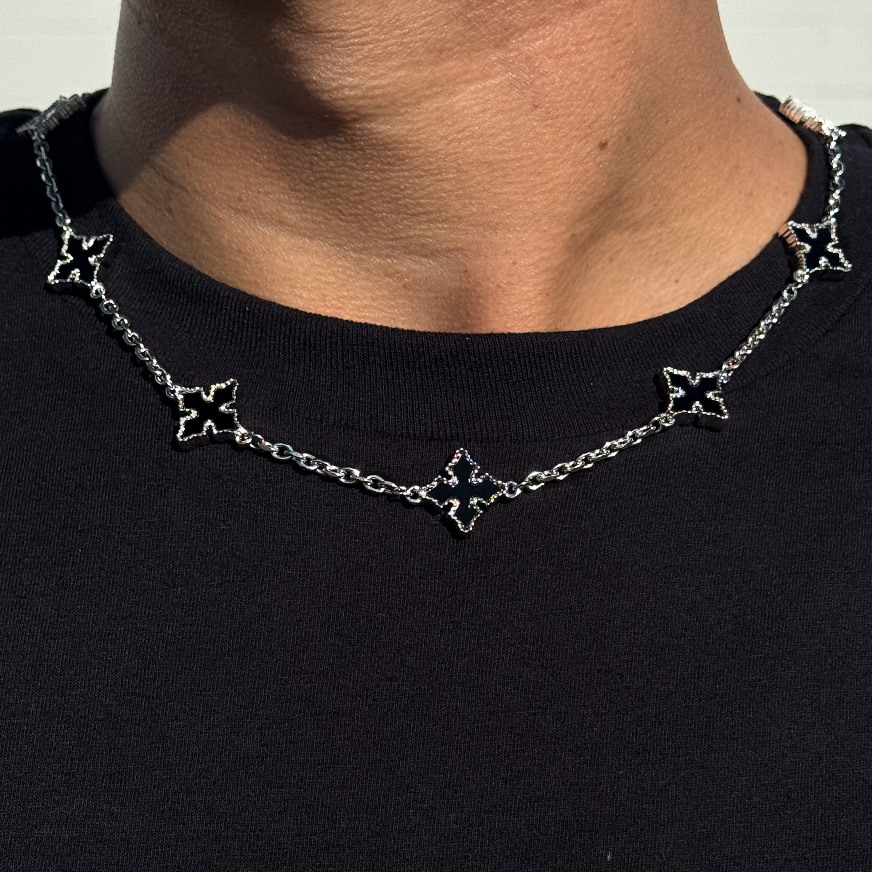 Close-up of Multi Cross Chrome Inspired Chain - featuring silver chain and black enamel cross charms on neck.