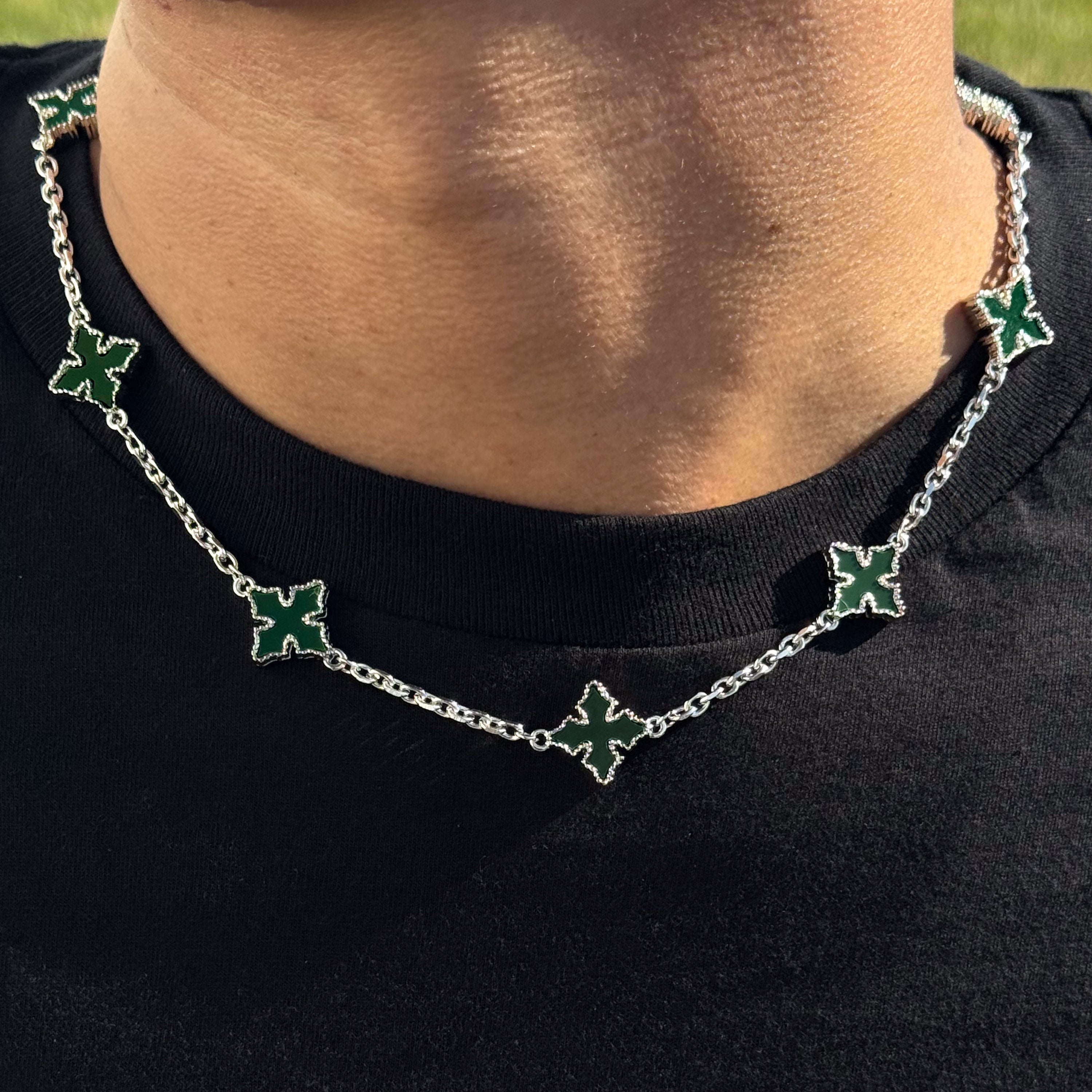 Close-up of Multi Cross Chrome Inspired Chain in green enamel with silver finish worn around neck.