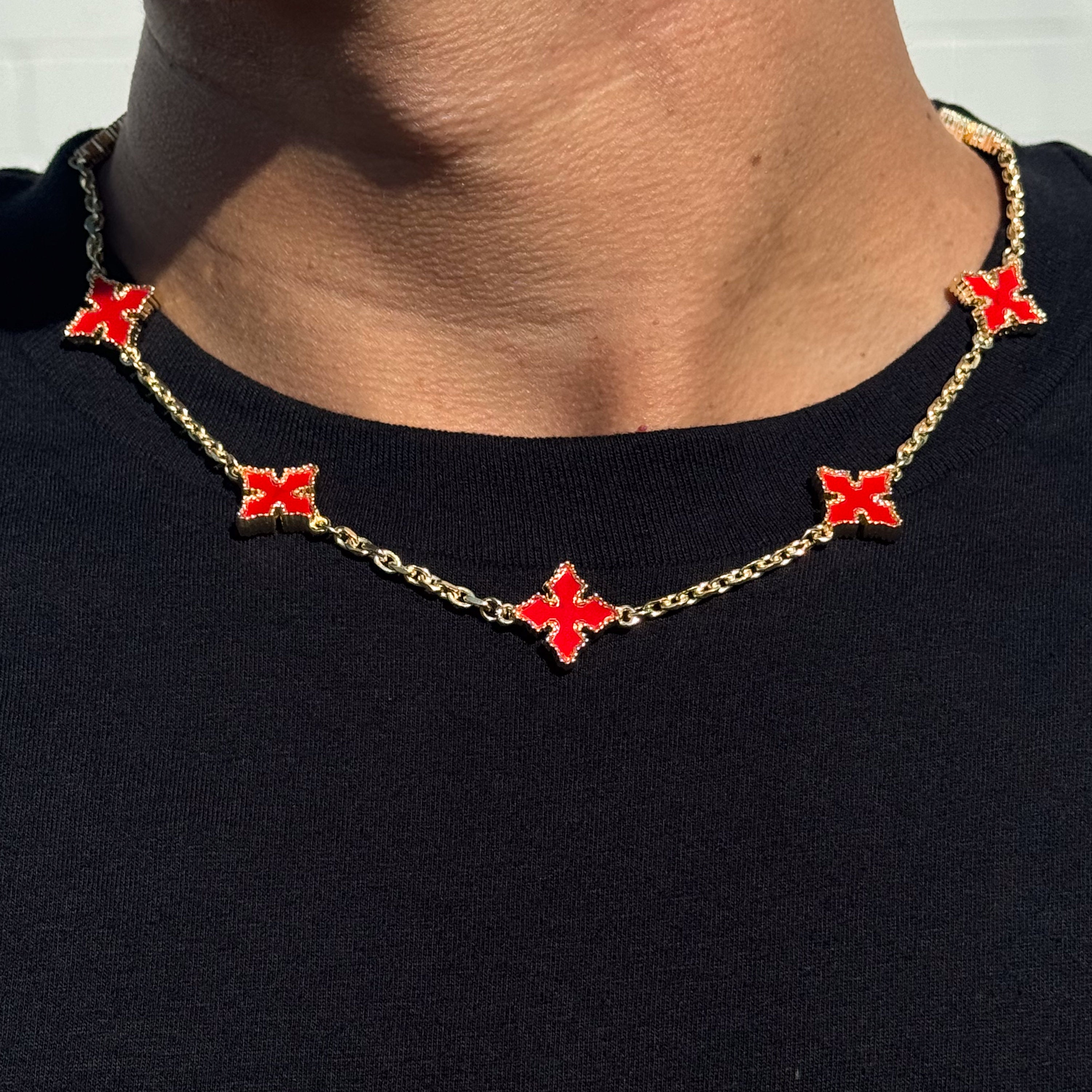 Close-up of Multi Cross Chrome Inspired Chain - featuring gold chain and red enamel cross charms on neck.