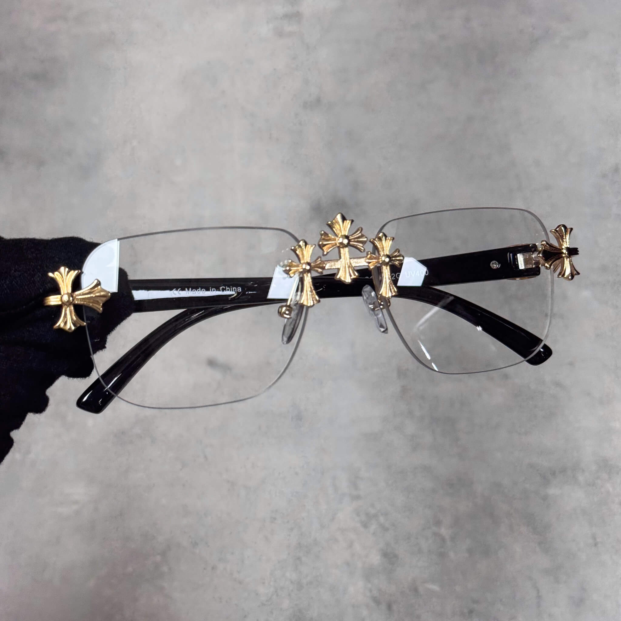 Rimless Solid Triple Cross Sunglasses with clear lenses and detailed gold cross trim.