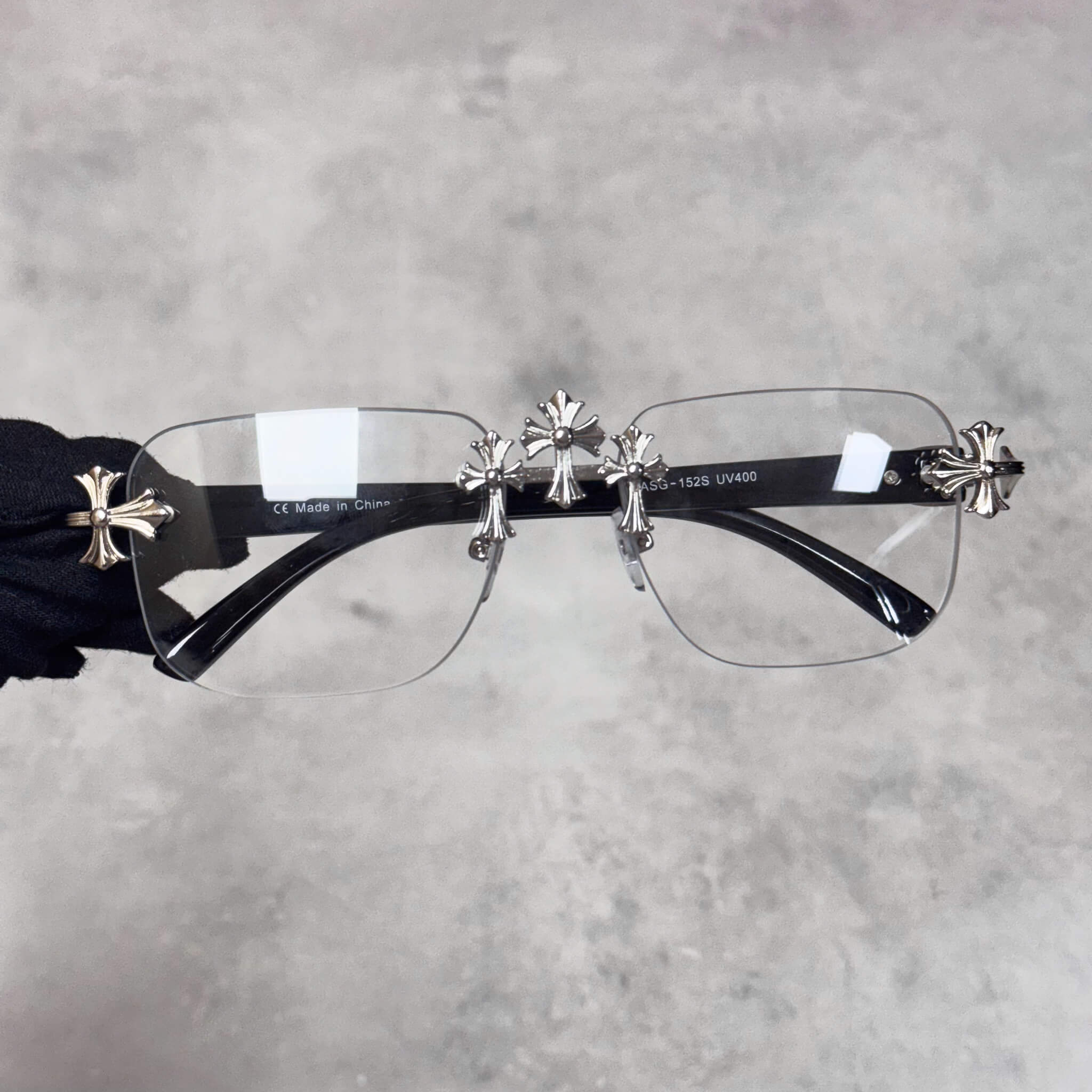 Solid Triple Cross Sunglasses with clear lenses and silver cross accents on black temples.
