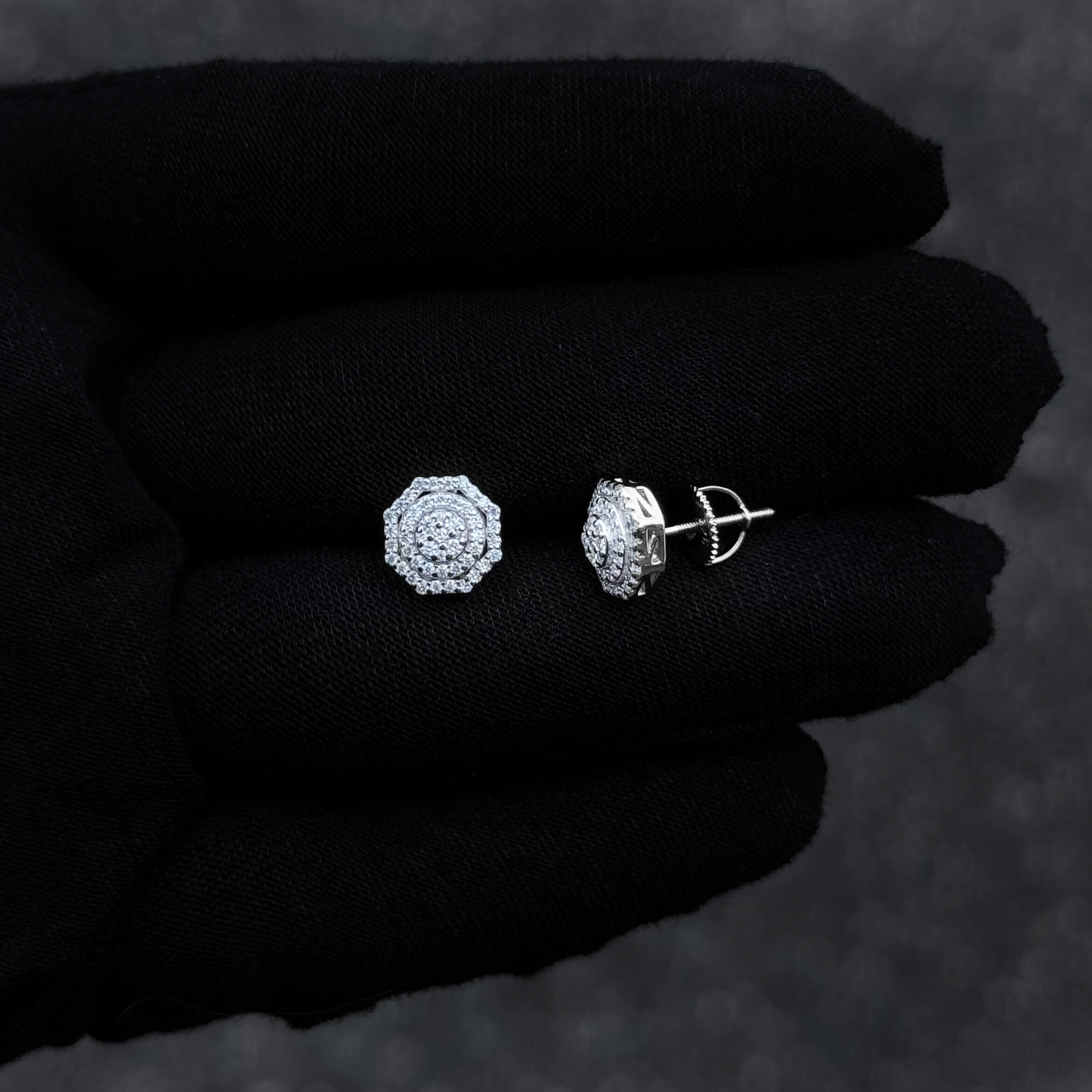 Sterling silver 10mm moissanite cluster earrings with screw-back posts shown on glove.