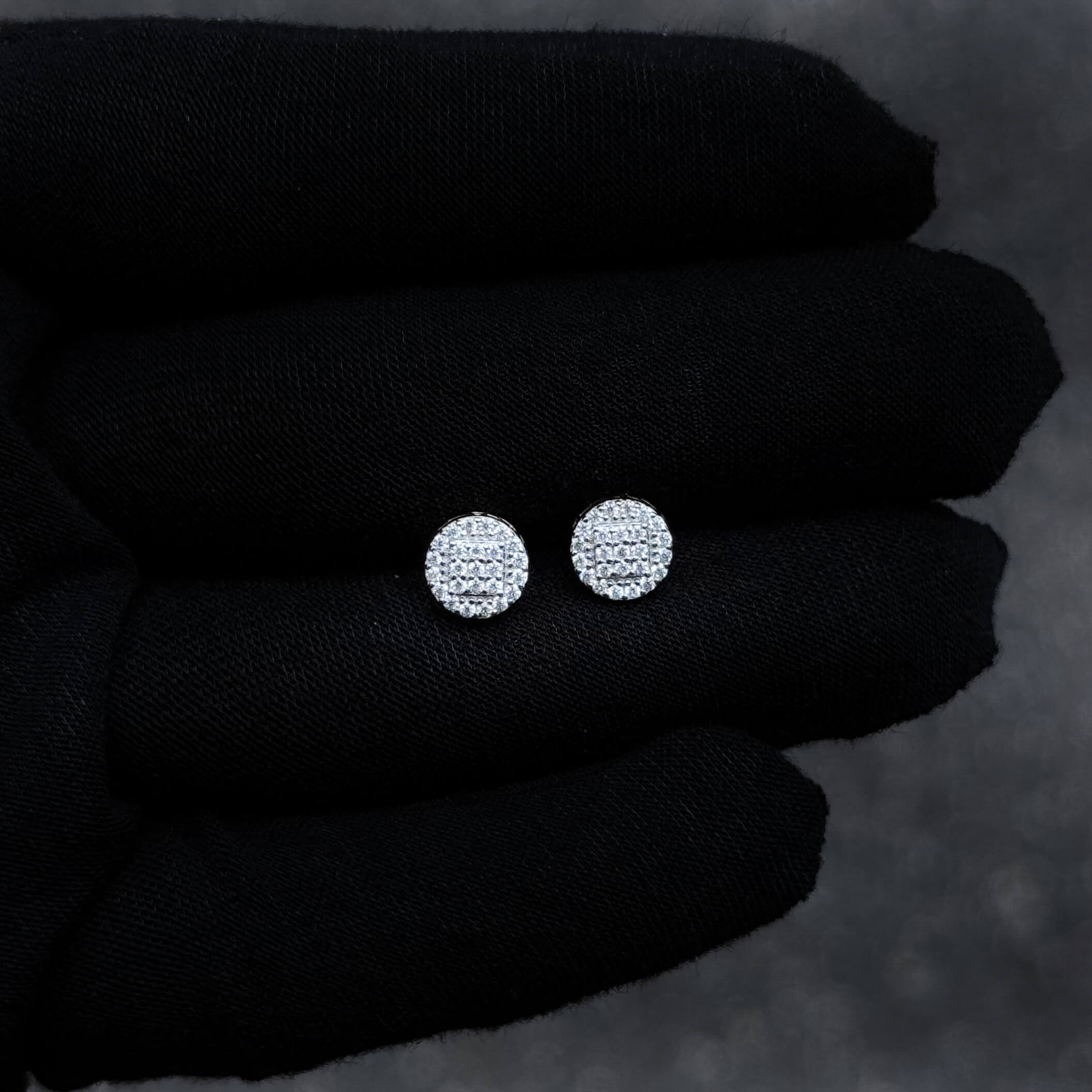 Small 7mm sterling silver moissanite cluster stud earrings displayed on black glove for detail view.